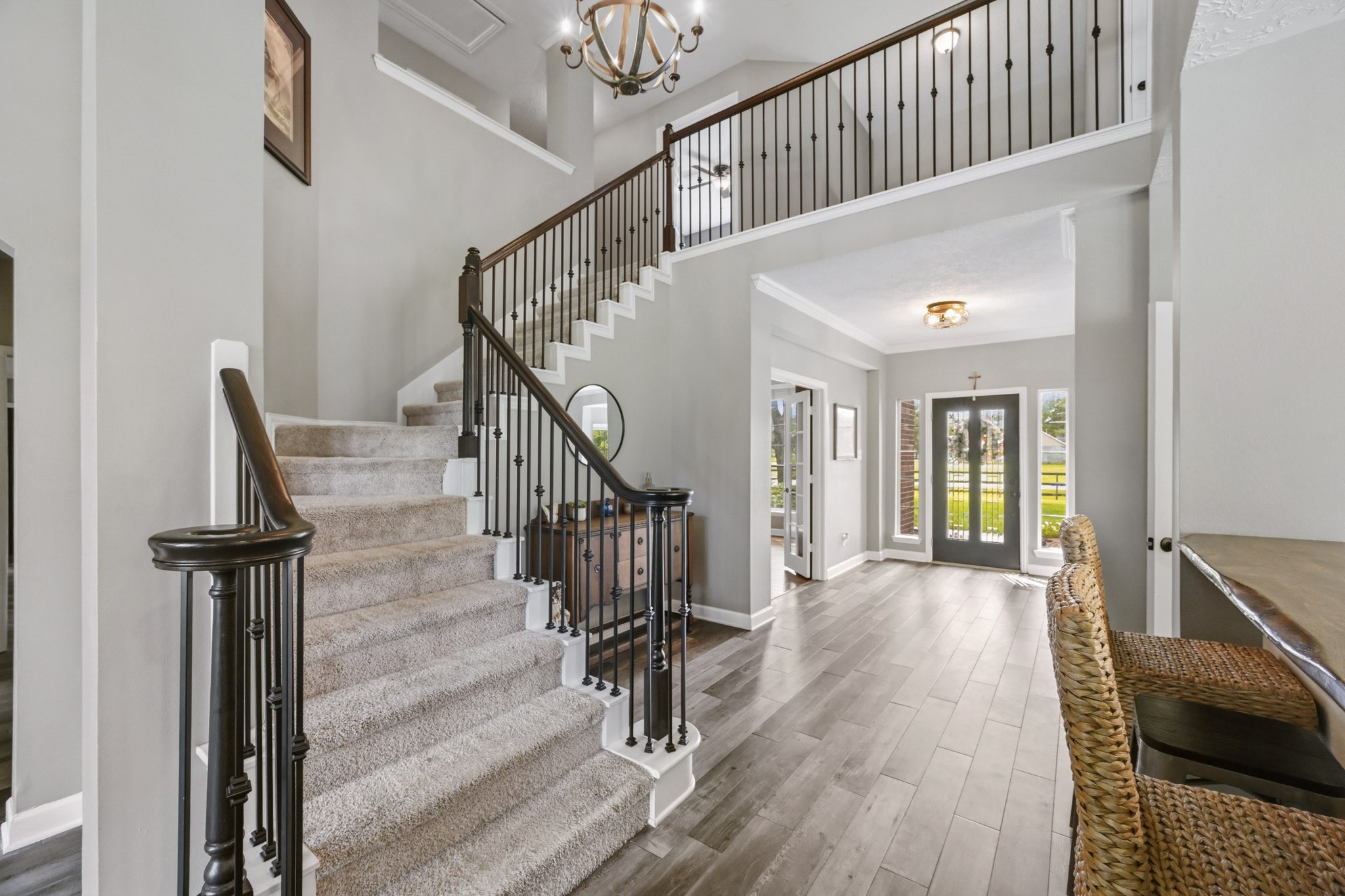 Grand staircase and welcoming entry with views of the private study behind French doors.