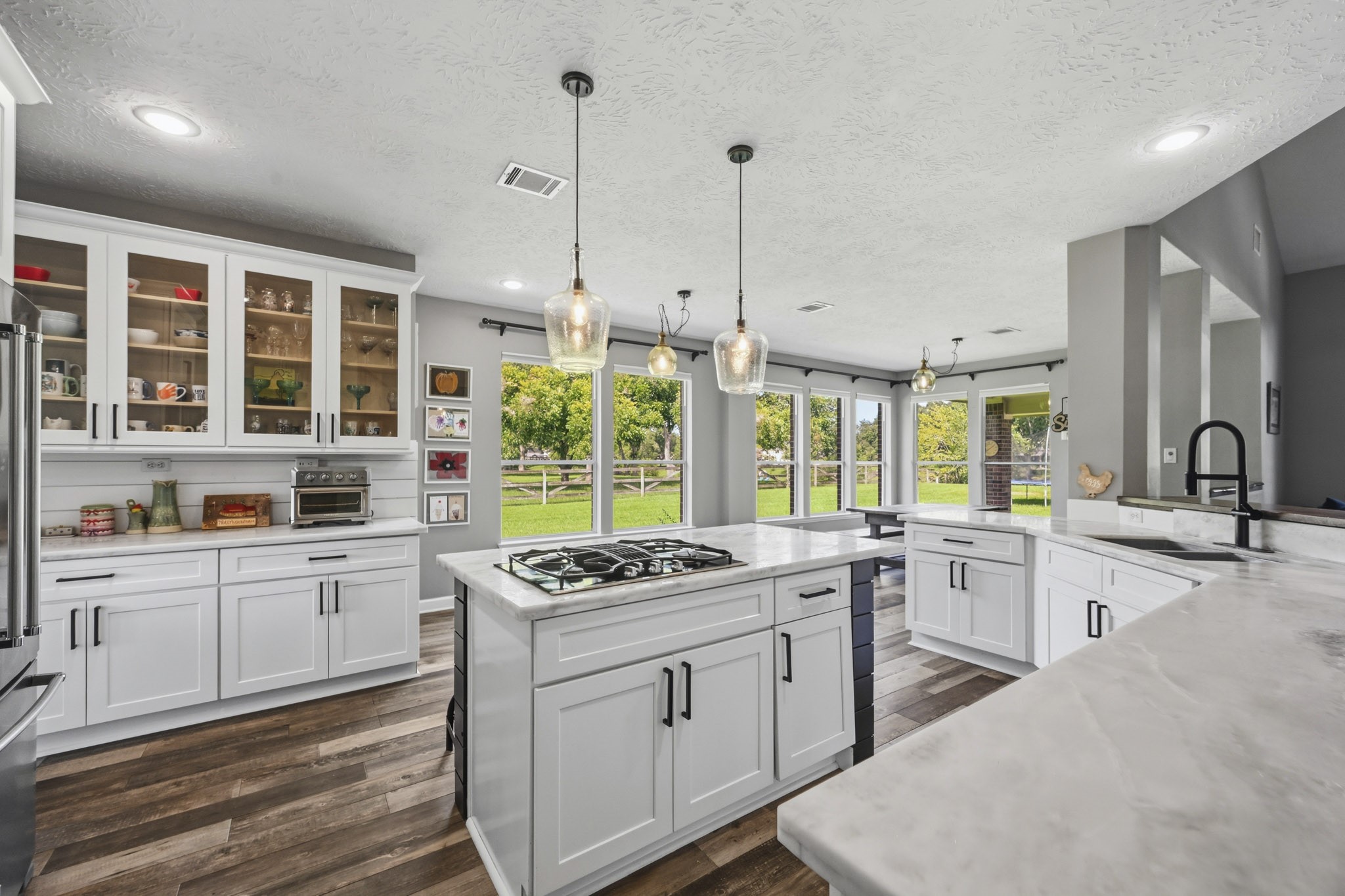 Butlers pantry with beautiful views of the side and backyard, marble countertops, and spacious island seating.