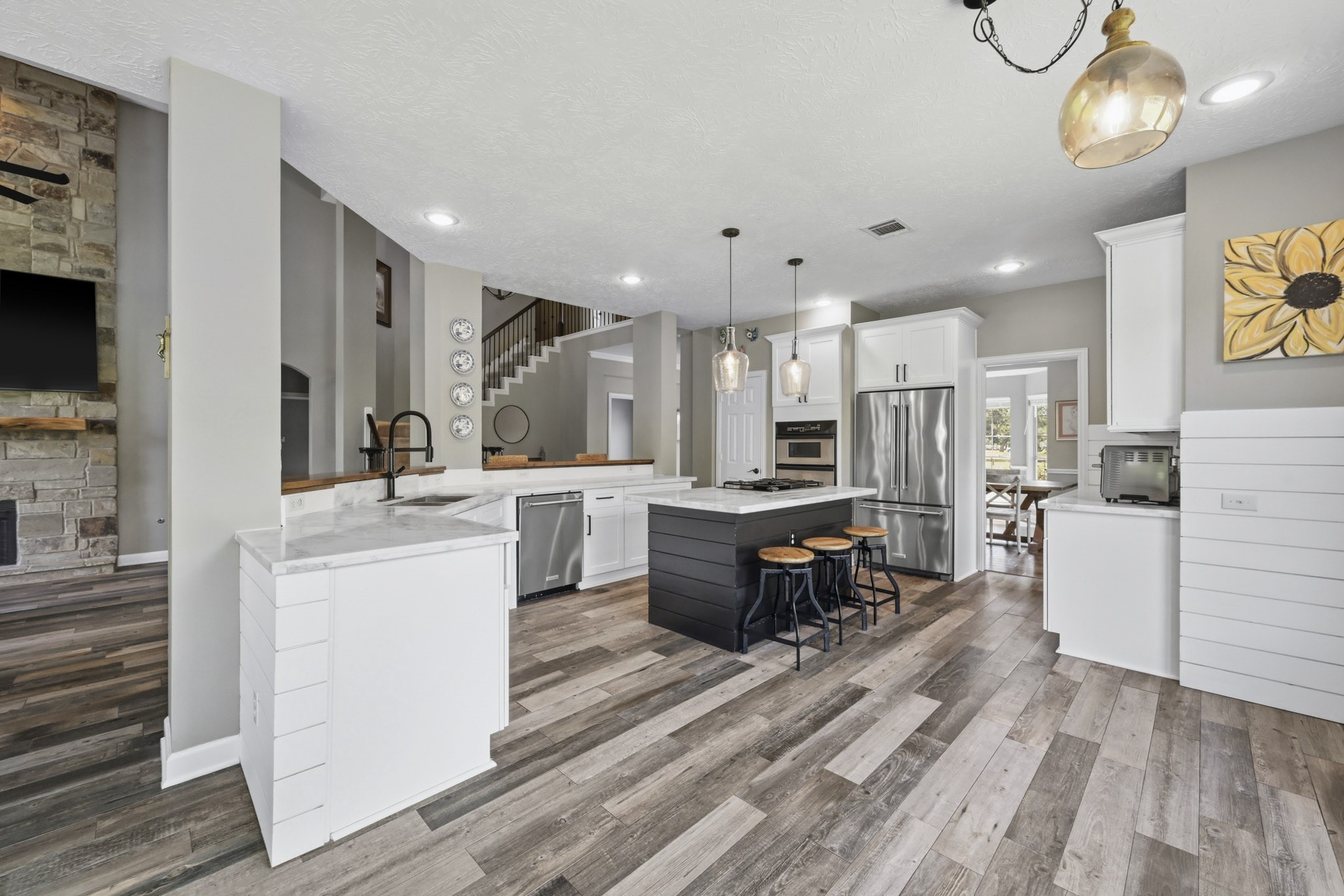 Chef-inspired kitchen showcasing elegant marble countertops and abundant cabinetry. View of Open kitchen which lends itself to leisurely entertainment w/beautiful Marble countertops, sit up island, stainless appliances, butler's pantry, convection oven, lots of natural sunlight