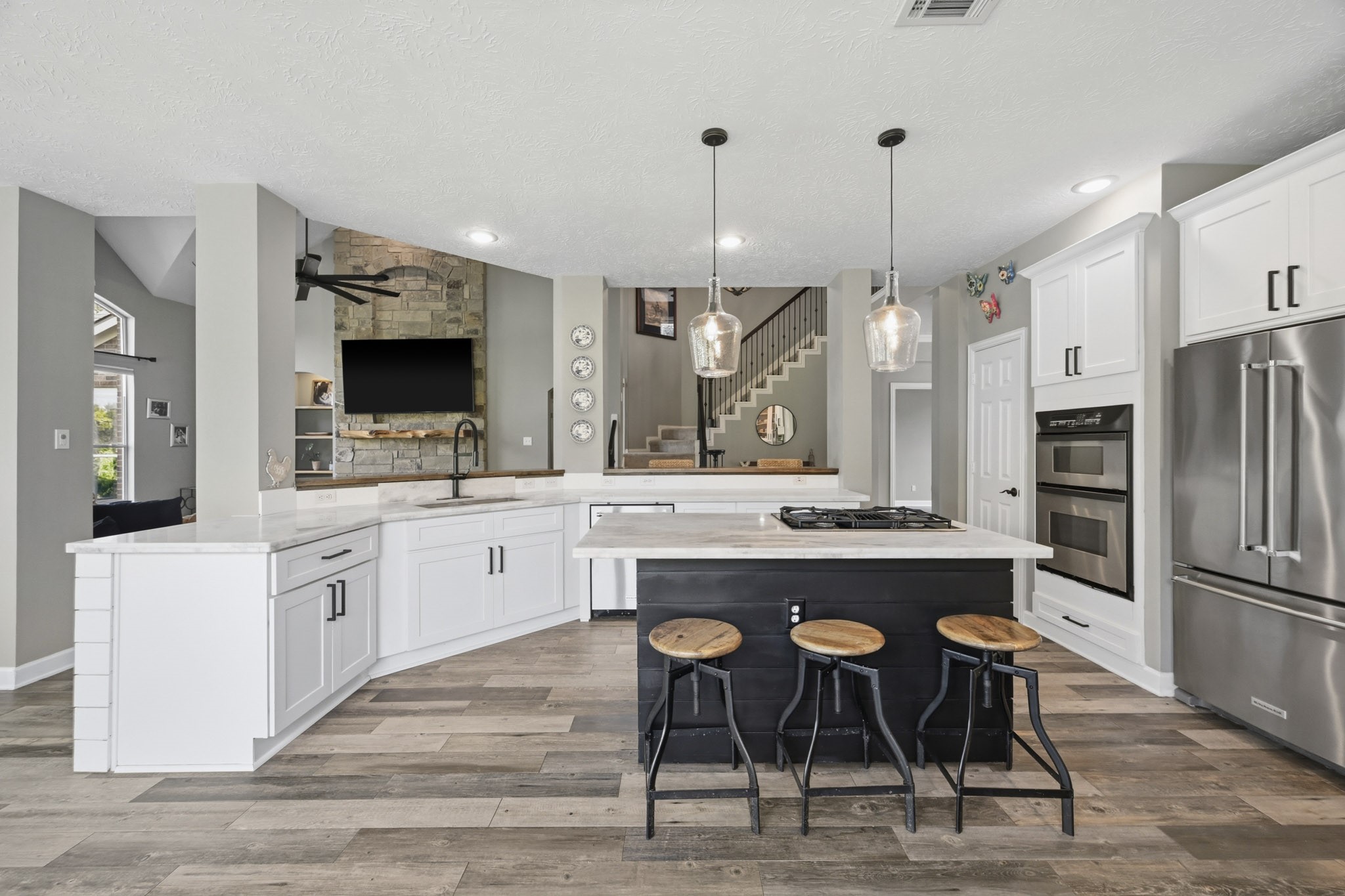 Gourmet kitchen with large island, breakfast bar, and multiple gathering spaces for entertaining.