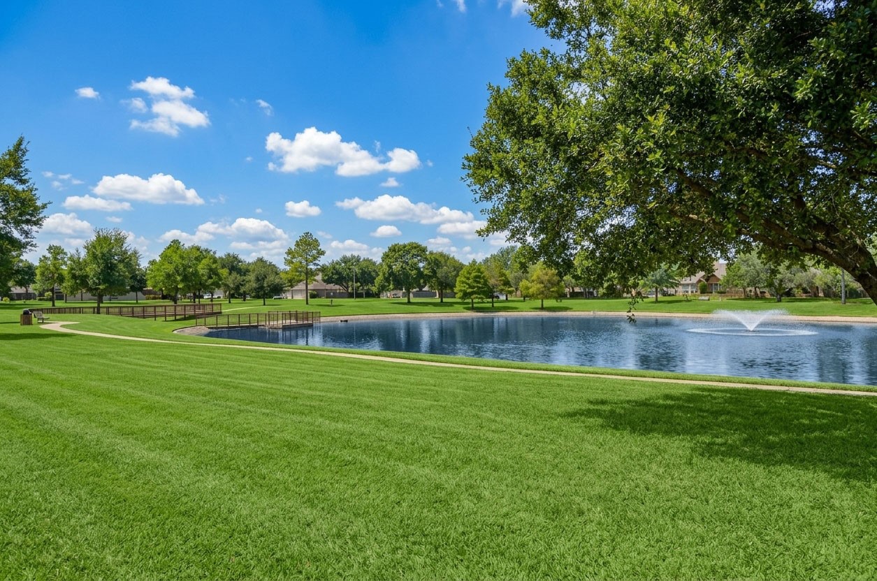 Enjoy peaceful views of the lake and open green space right behind the home, with mature trees and a wrought-iron fence that keeps the view open and inviting.