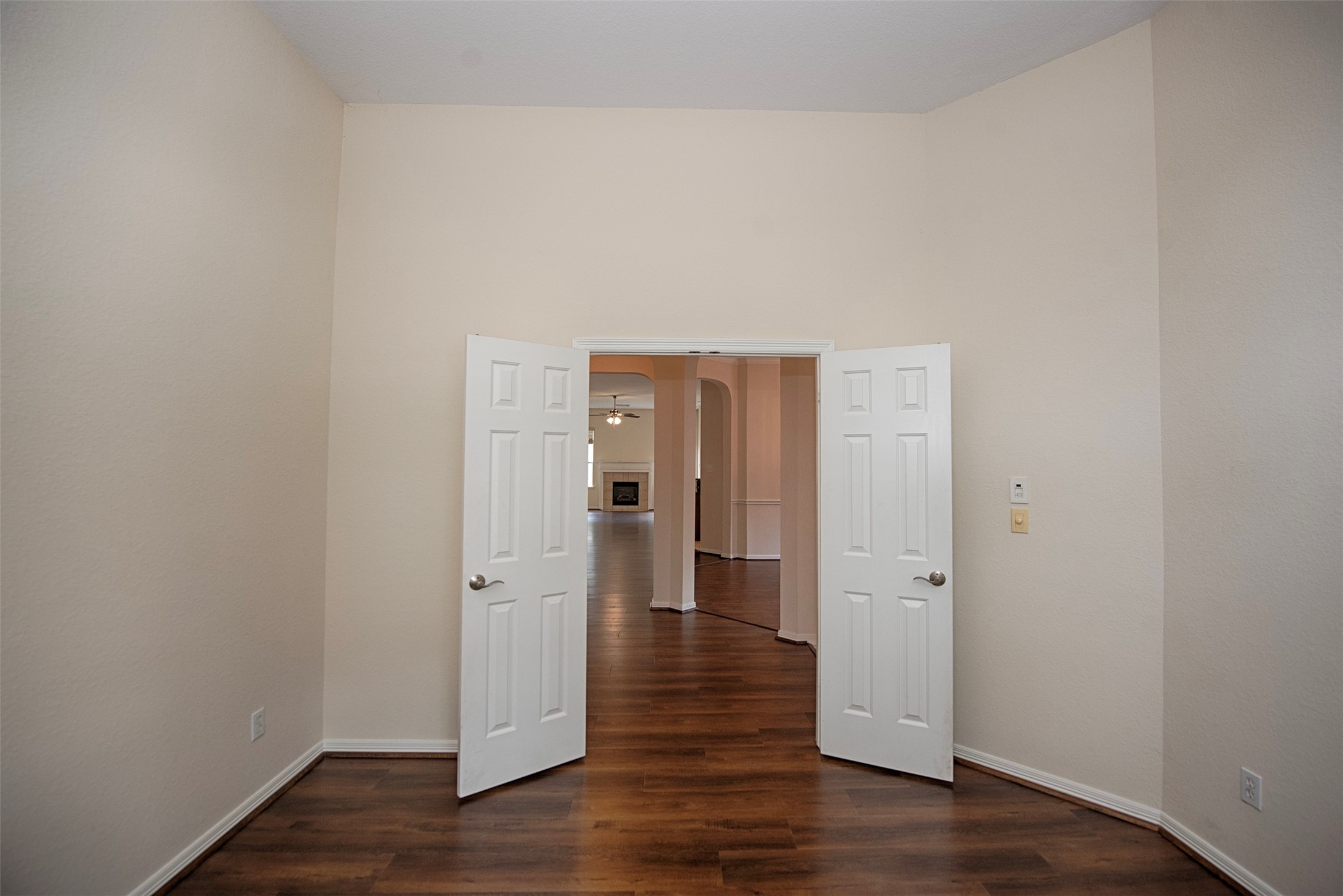 A view of the home office showing the gorgeous laminate wood floors, high ceiling and easy access to the rest of the home.  This room easily has enough room to install a closet and use it for a fourth bedroom.
