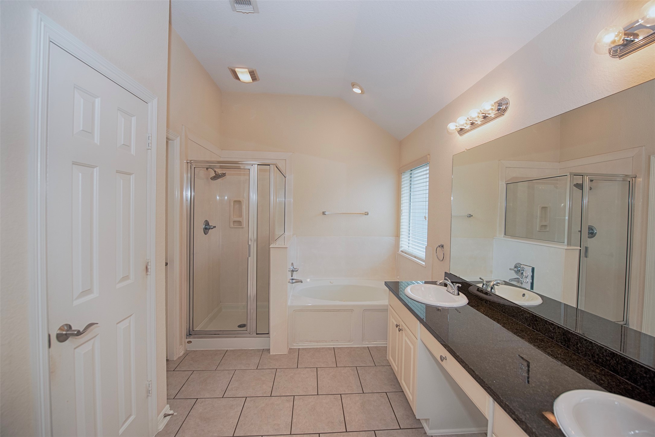 Entry to the en suite bathroom which features double vanity and separate shower and Jacuzzi tub.