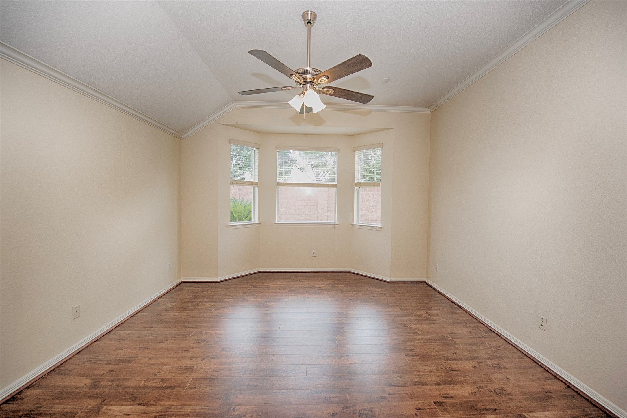 Large primary bedroom with vaulted ceiling and bay windows. Will easily fit your king sized furniture.