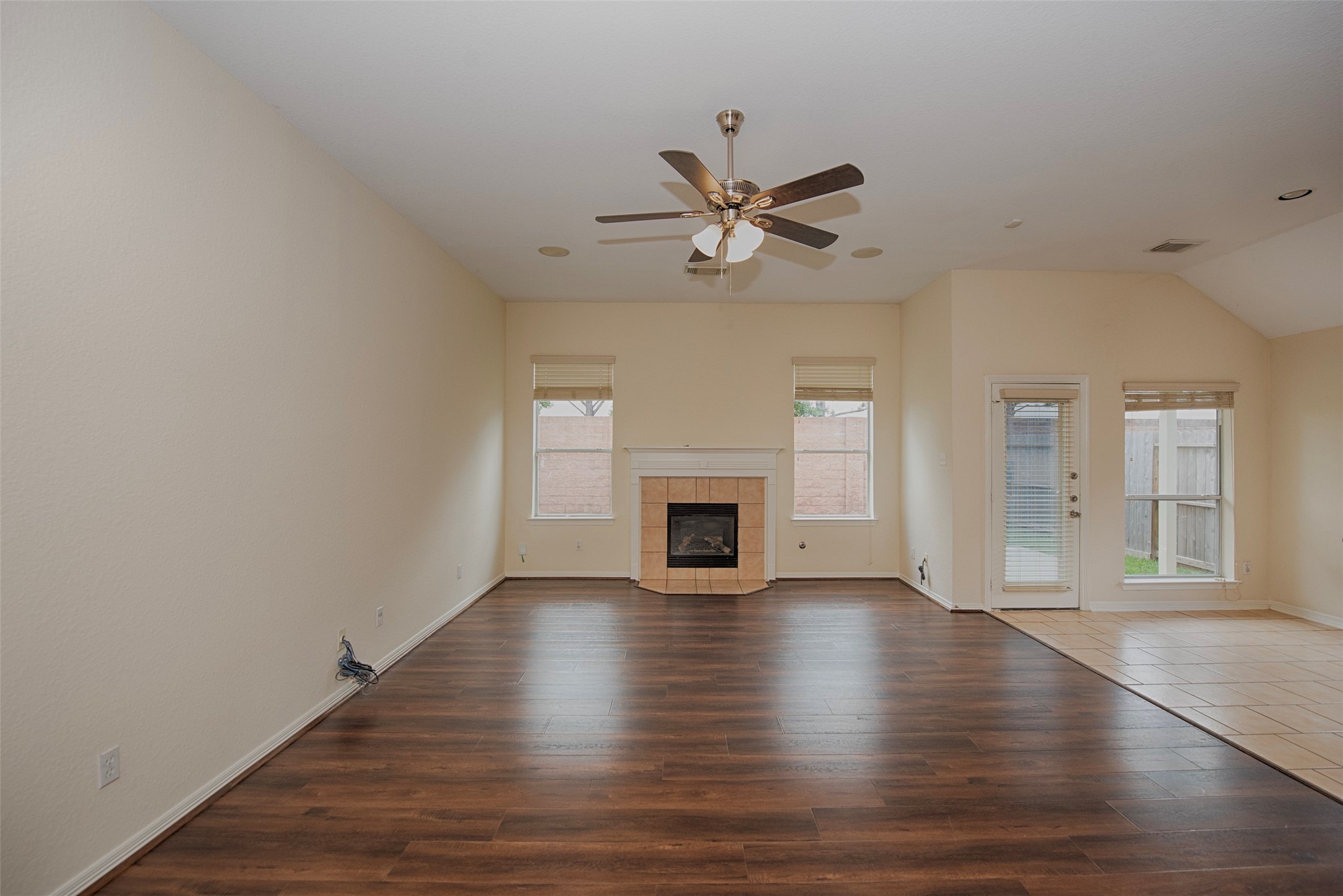 Gorgeous family room features a gas log fireplace as well as beautiful laminate wood floors.