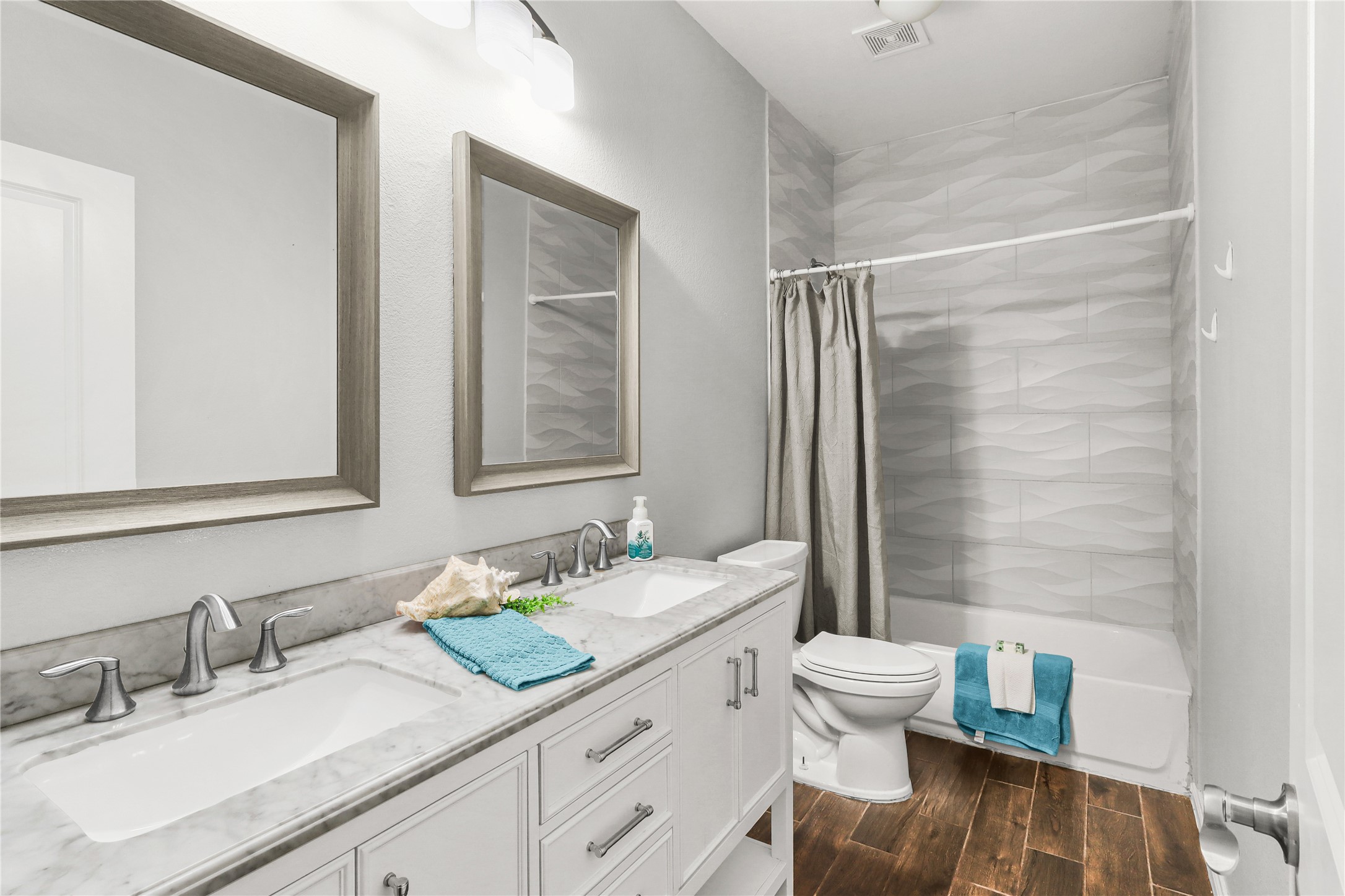 Second bathroom features double sink vanity, and shower/tub with upgraded tilework to match master bathroom.