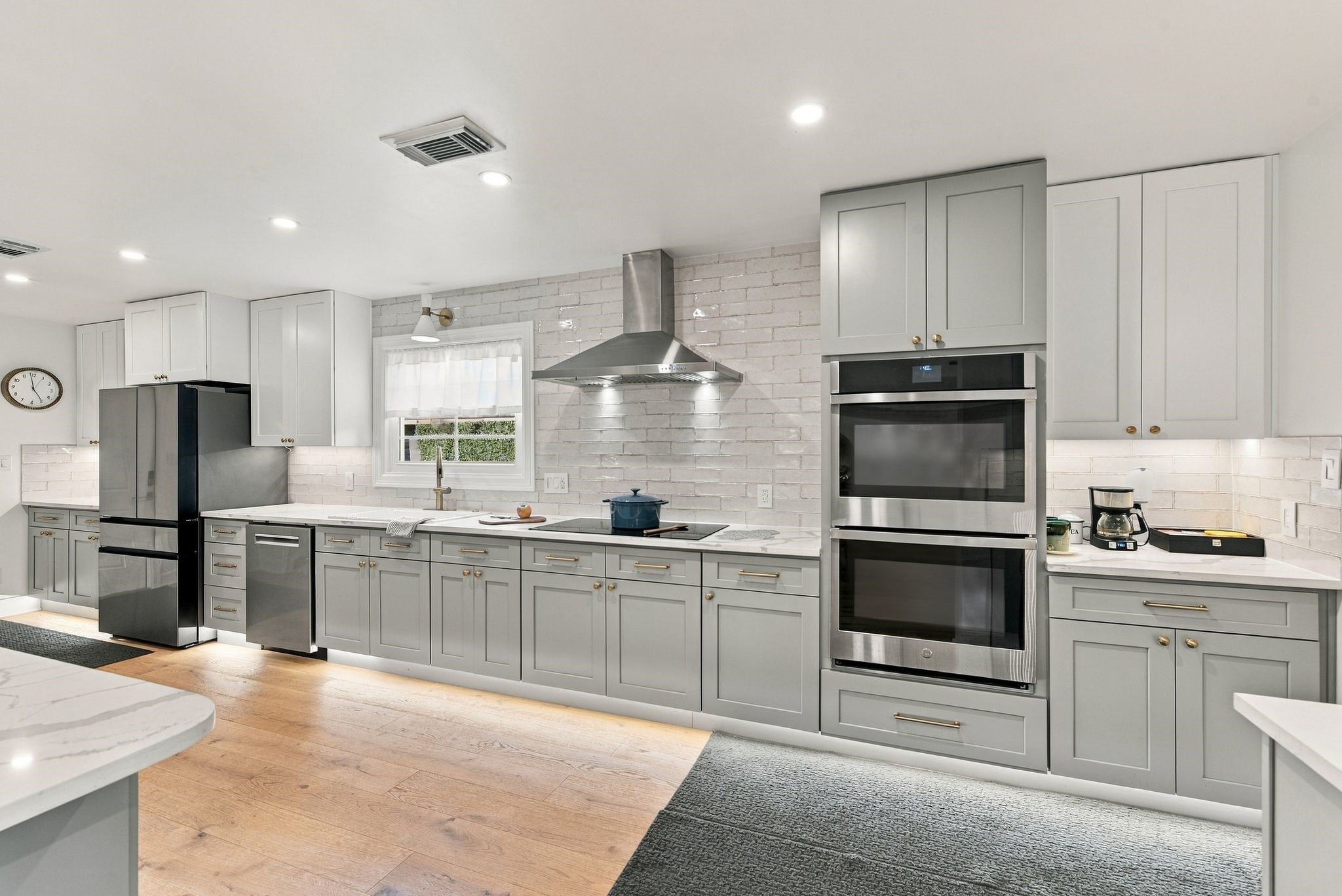 The kitchen has top of the line appliances with double ovens, beverage refrigerator, and induction stove.