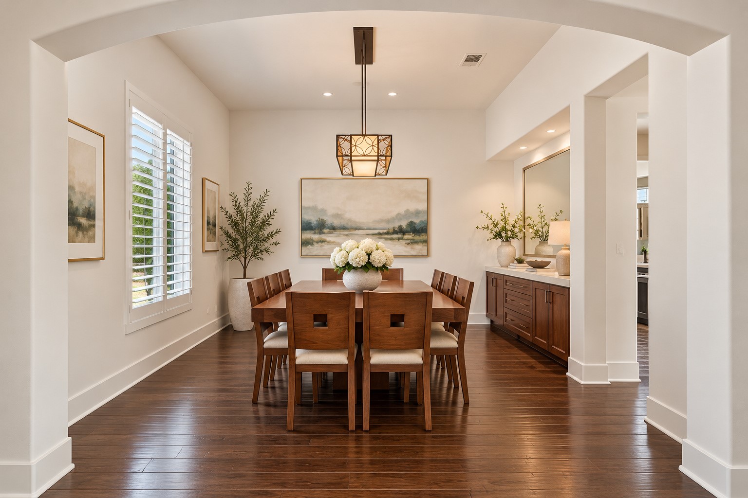 Beautiful formal dining room featuring soaring ceilings, elegant lighting, rich hardwood floors, and an open, airy design perfect for entertaining.