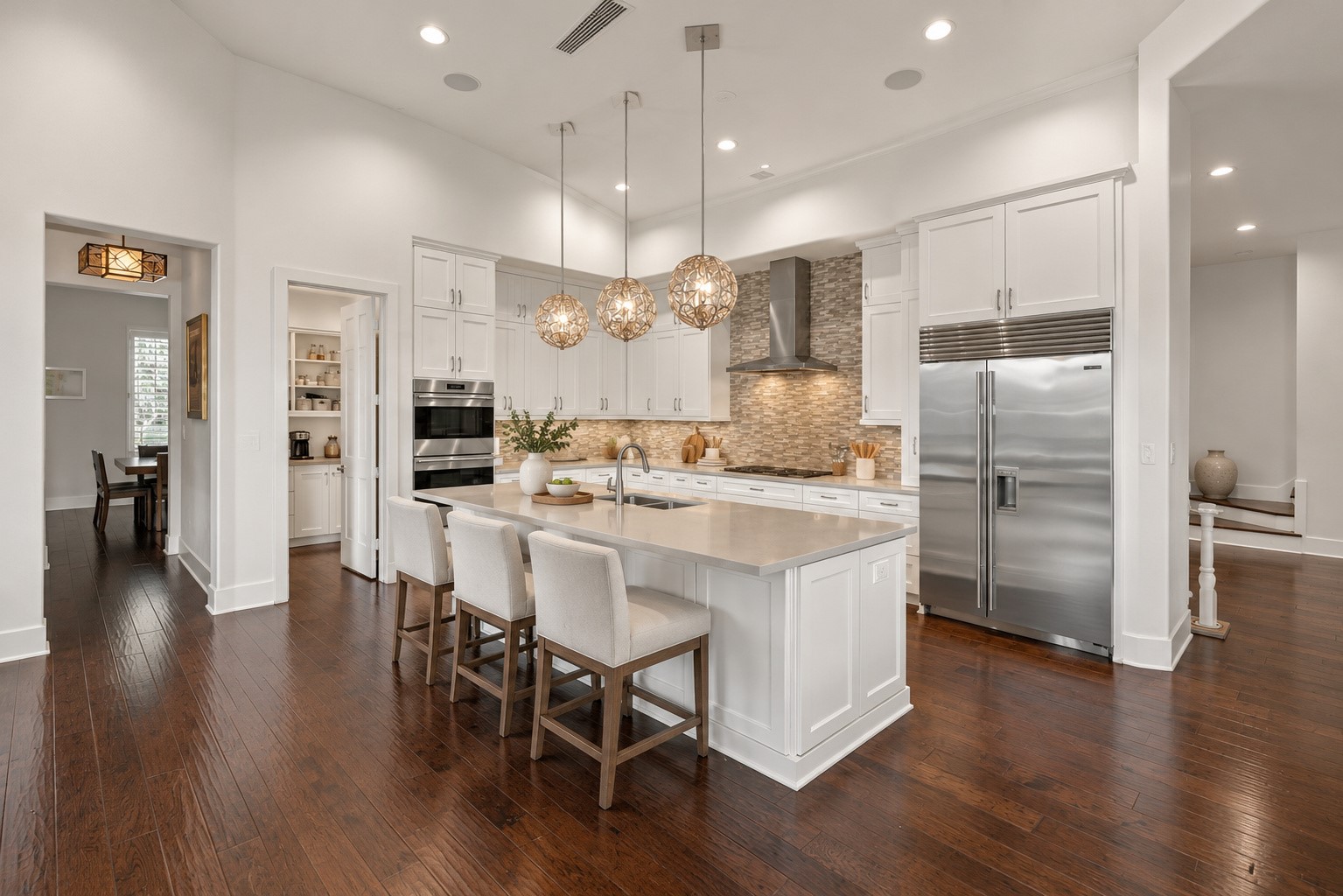 Gourmet kitchen featuring a spacious center island, elegant pendant lighting, custom cabinetry, and premium stainless steel appliances.