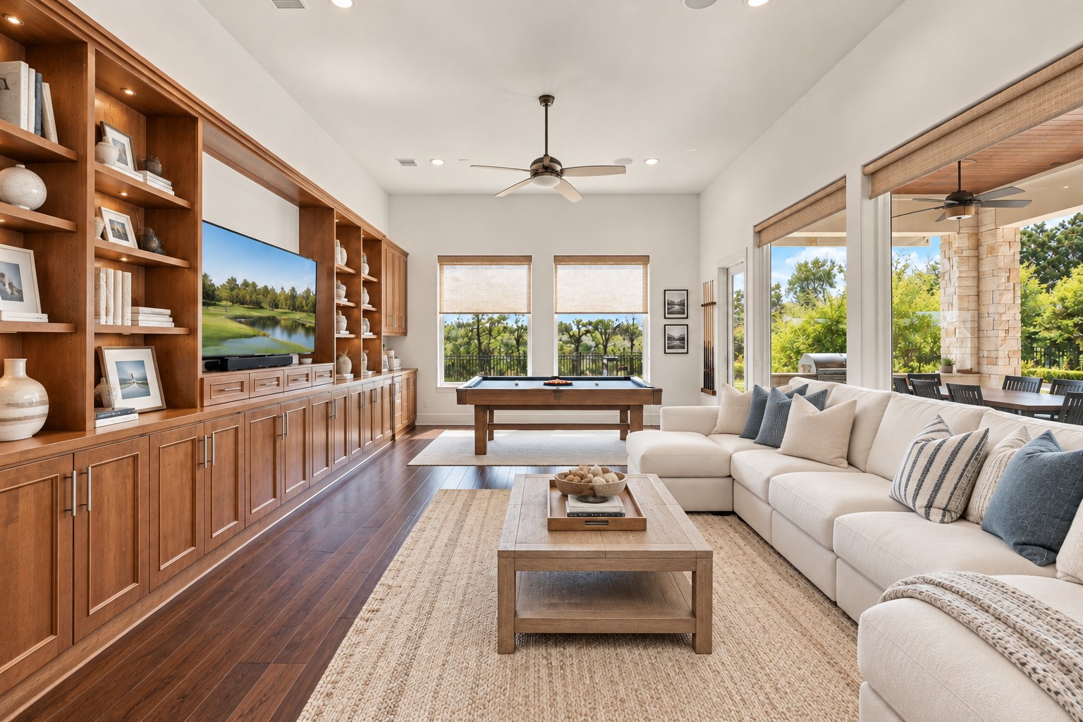 Game room featuring beautiful hardwood floors, custom built-ins, and an abundance of natural light. A comfortable and inviting space perfect for entertaining, relaxing, or enjoying time with family and friends.