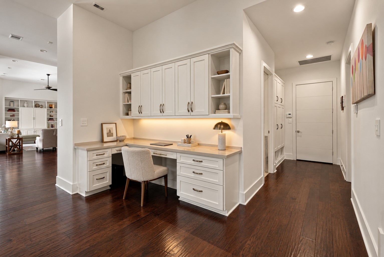 Beautifully designed built-in workspace featuring custom cabinetry, generous counter space, and rich hardwood floors, offering both style and functionality.