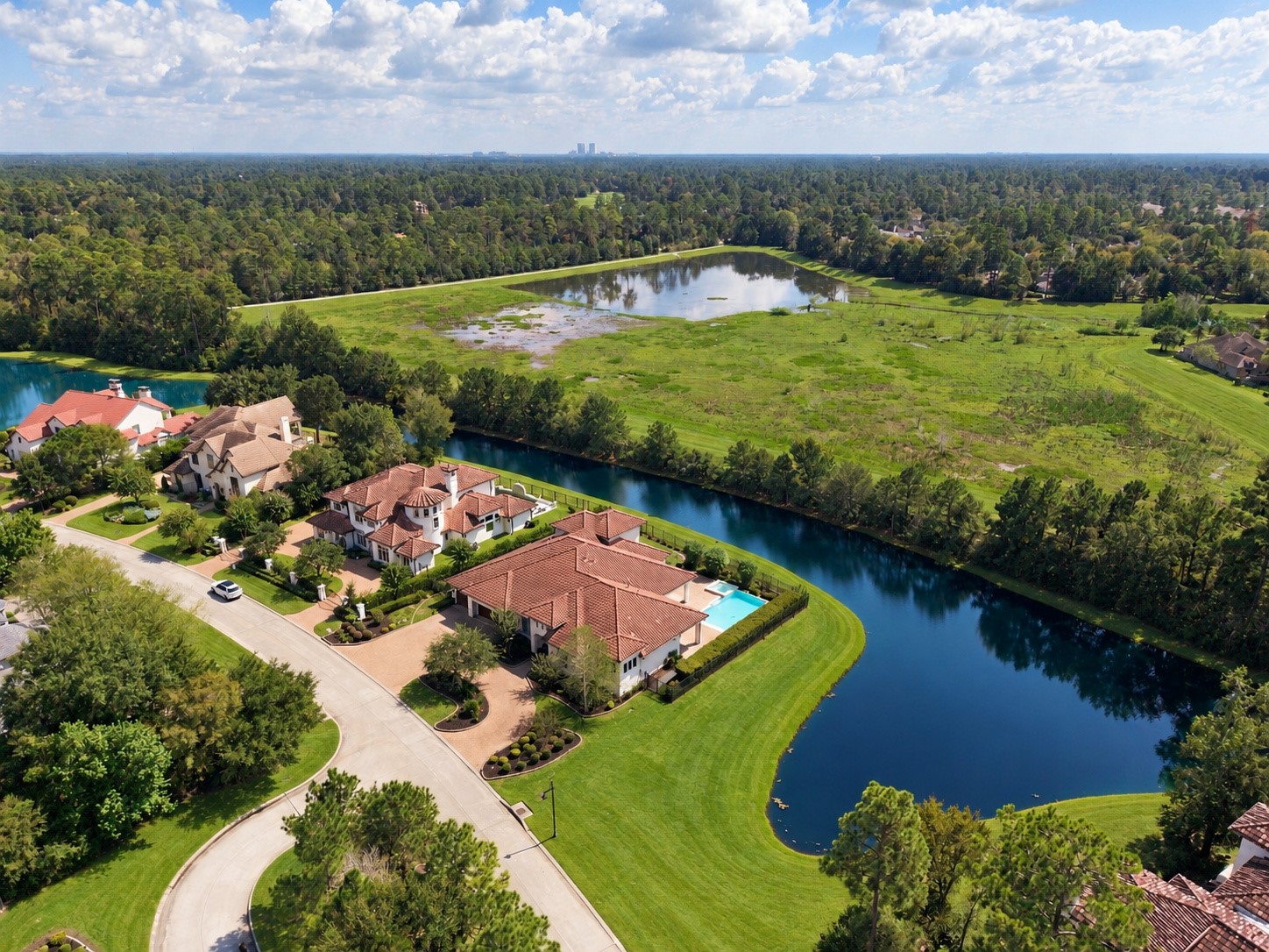 Spectacular aerial view showcasing the estate's unique peninsula setting, with sparkling water on both sides and breathtaking views in every direction