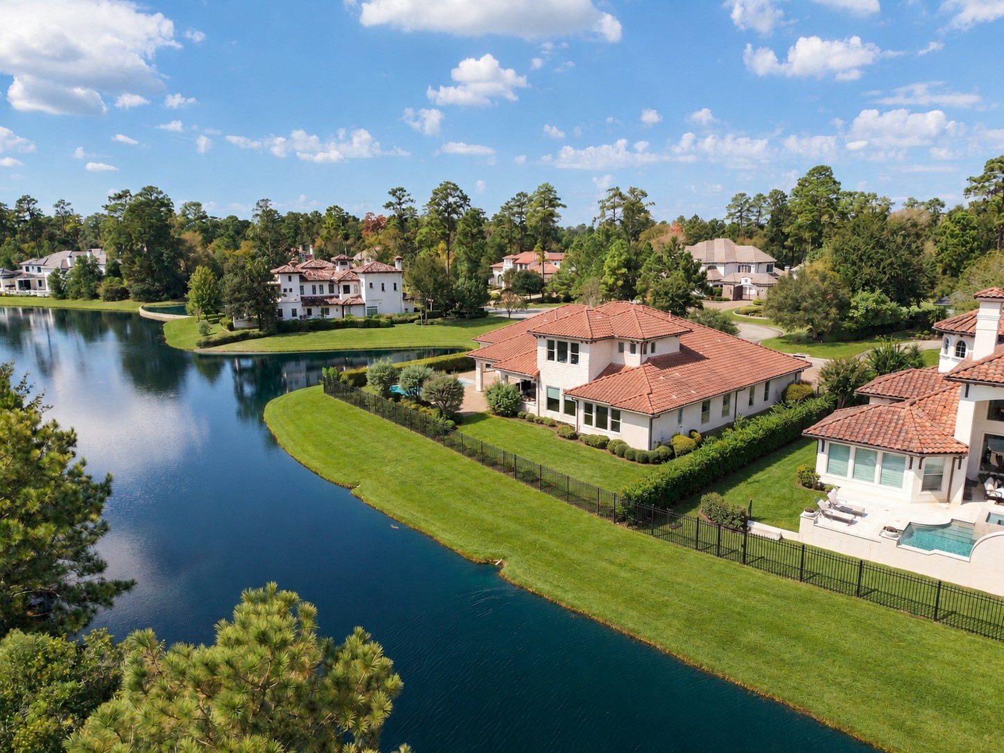 A stunning aerial perspective showcases the home's remarkable setting, with sweeping water views, lush green surroundings, and exceptional privacy.