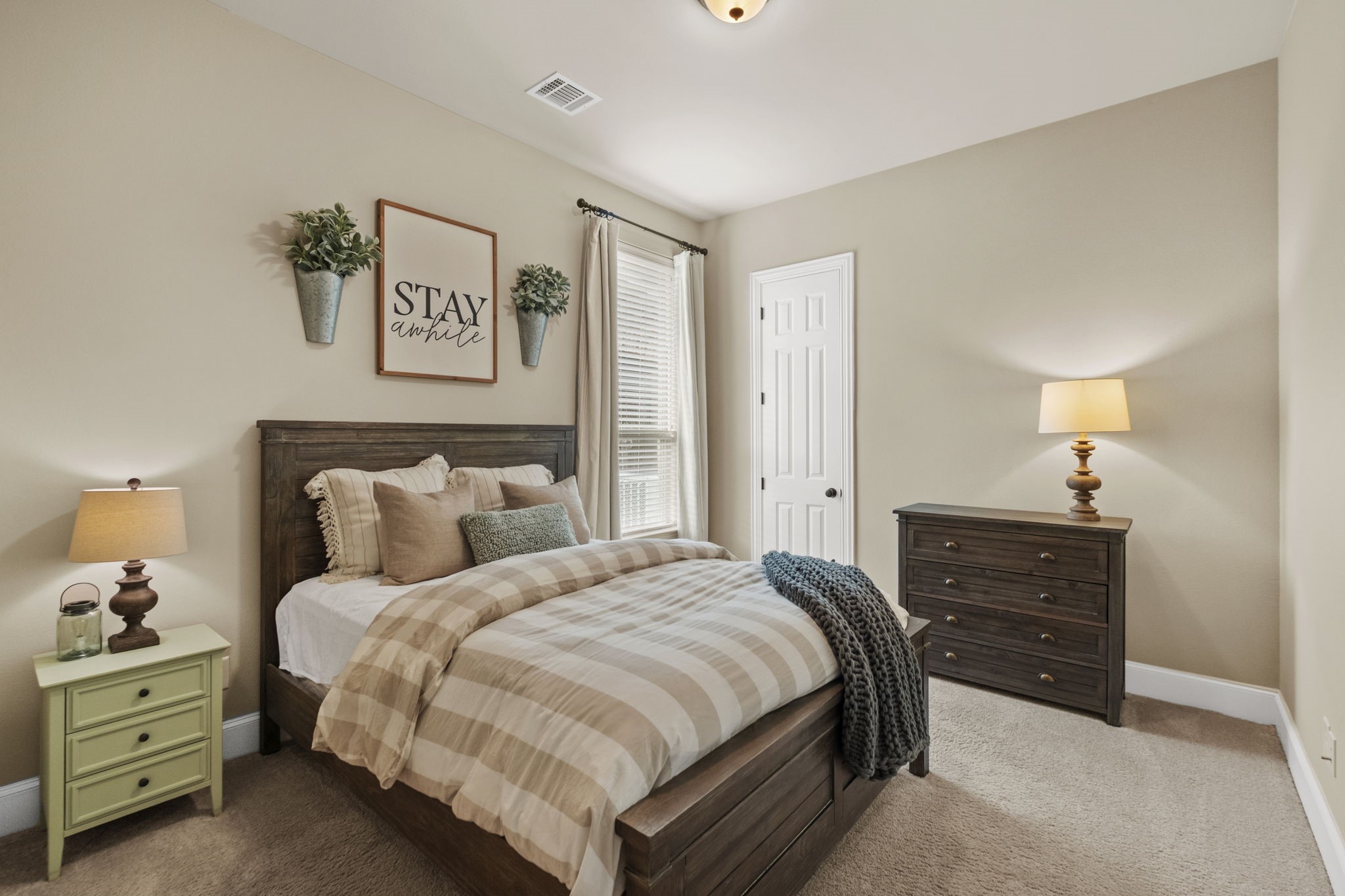 Generously sized secondary bedroom featuring plush carpeting, neutral painted walls, a large double-hung window with blinds, and a standard closet with a raised-panel interior door.