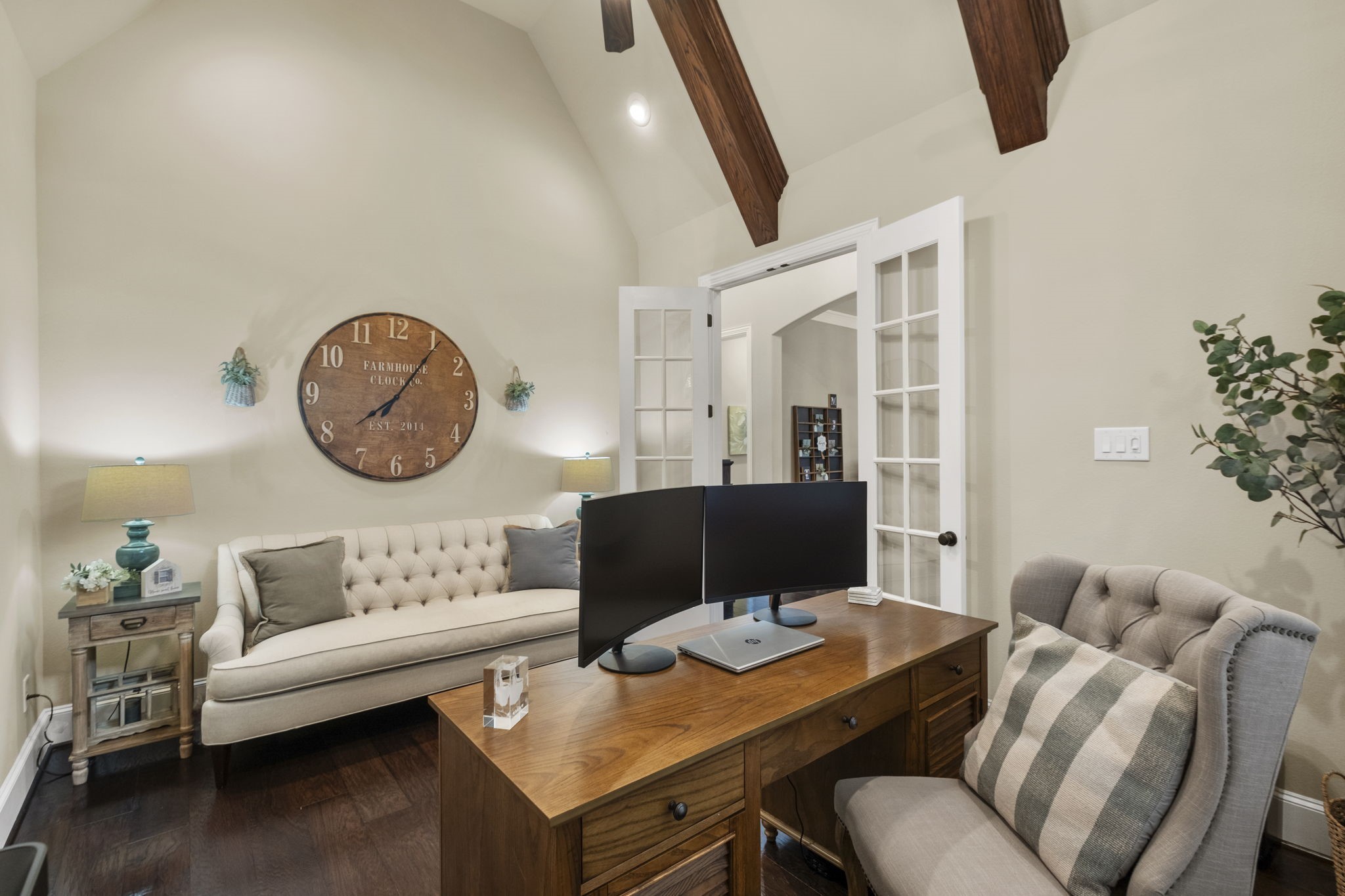 Alternate view of the private study showcasing double glass French door entry, vaulted ceilings with timber beam accents, recessed lighting, and dark hardwood floors.
