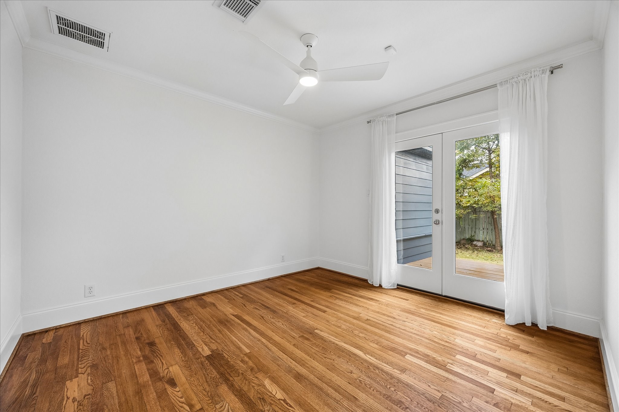 The second bedroom has hardwood floors and French doors that open to a private deck