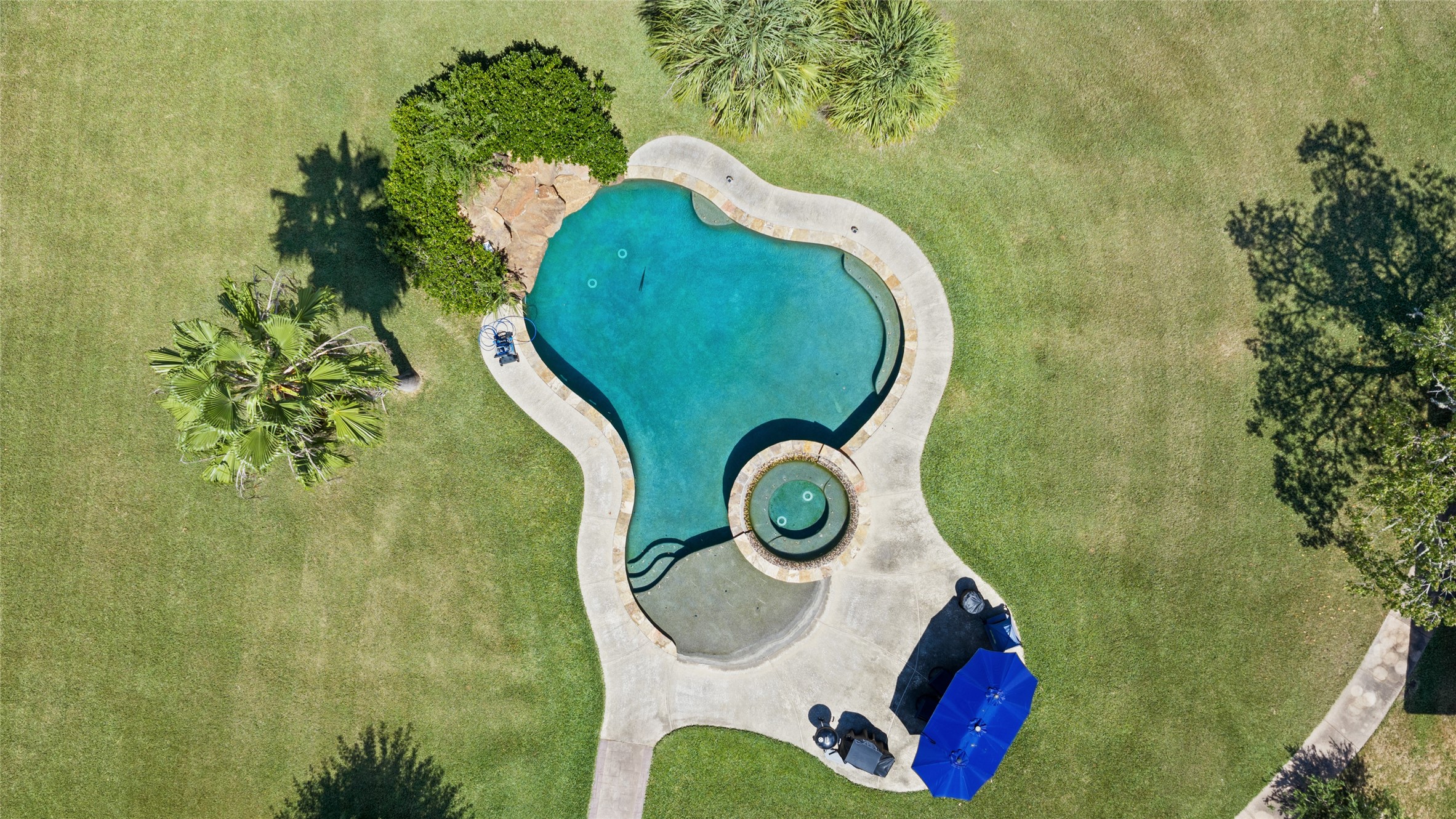 This aerial view shows off one of the best features of the property, the beach entry pool with connected hot tub.