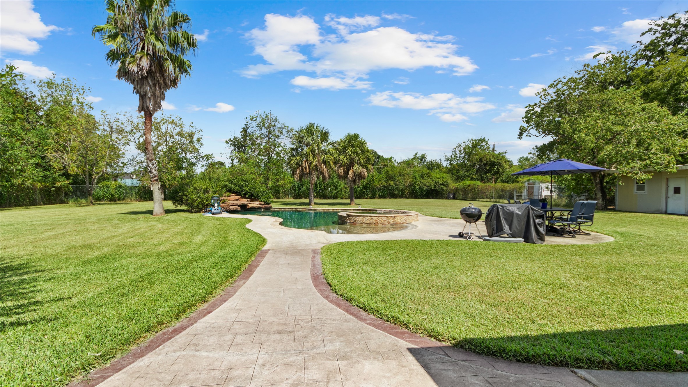 As you head toward the pool, you can really appreciate the privacy and space this backyard offers. To the very right, you can see the storage / workshop area and even a fenced off chicken coop area.