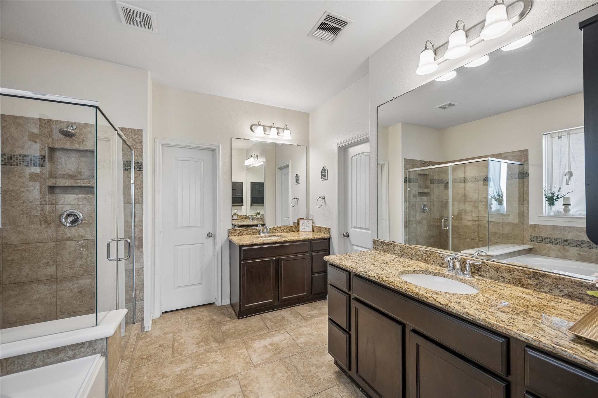 Primary bathroom with separate vanities.