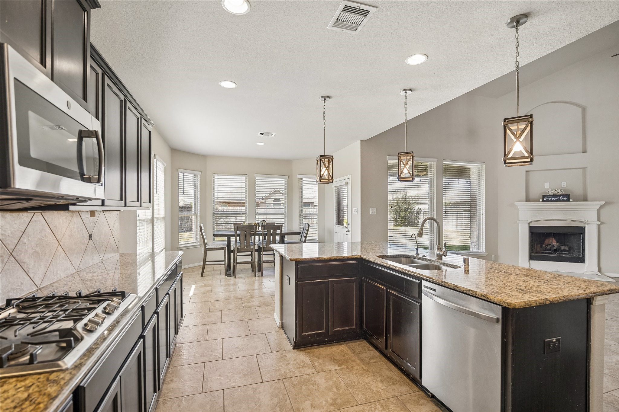 Open concept kitchen with stainless appliances and gas range.