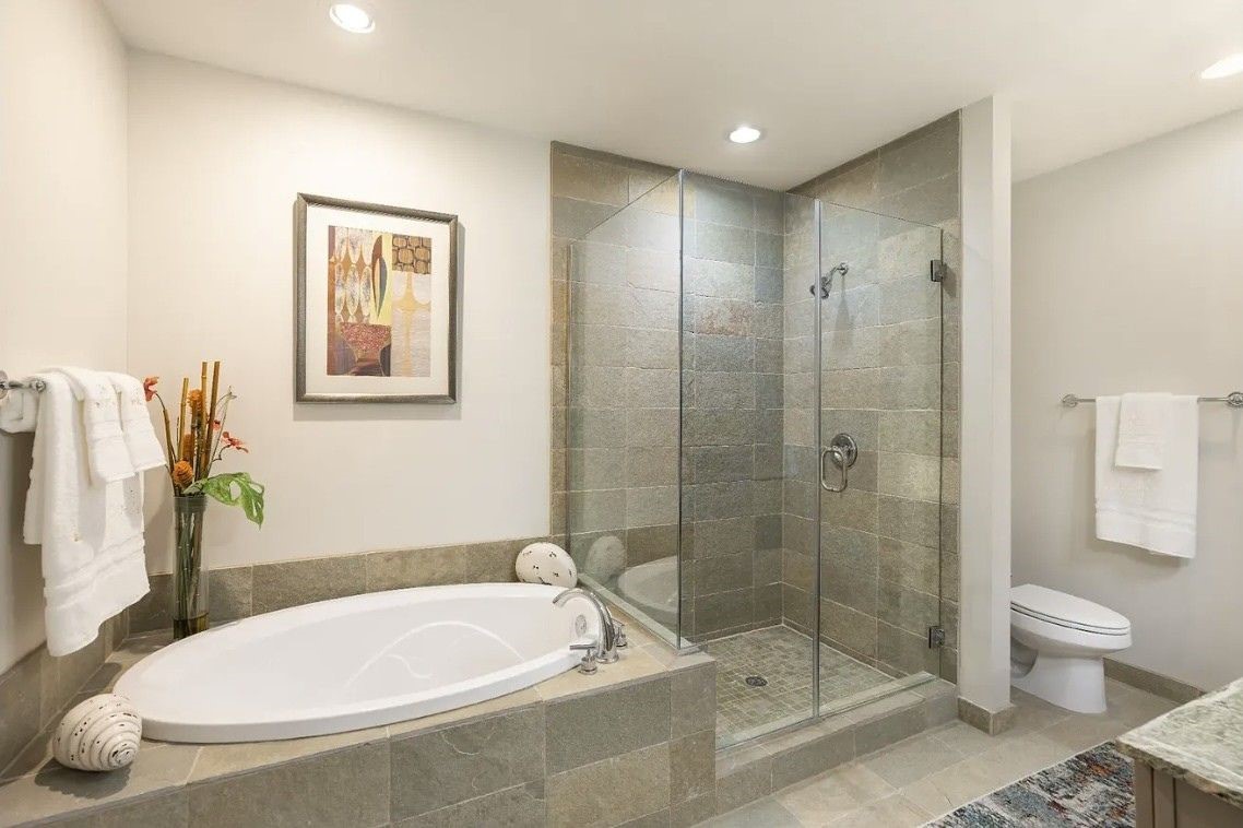 Indulge in a spa-inspired experience with a luxurious soaking tub, separate frameless glass walk-in shower and timeless tile surround. This beautifully appointed bathroom offers the perfect space to relax and recharge after a long day.