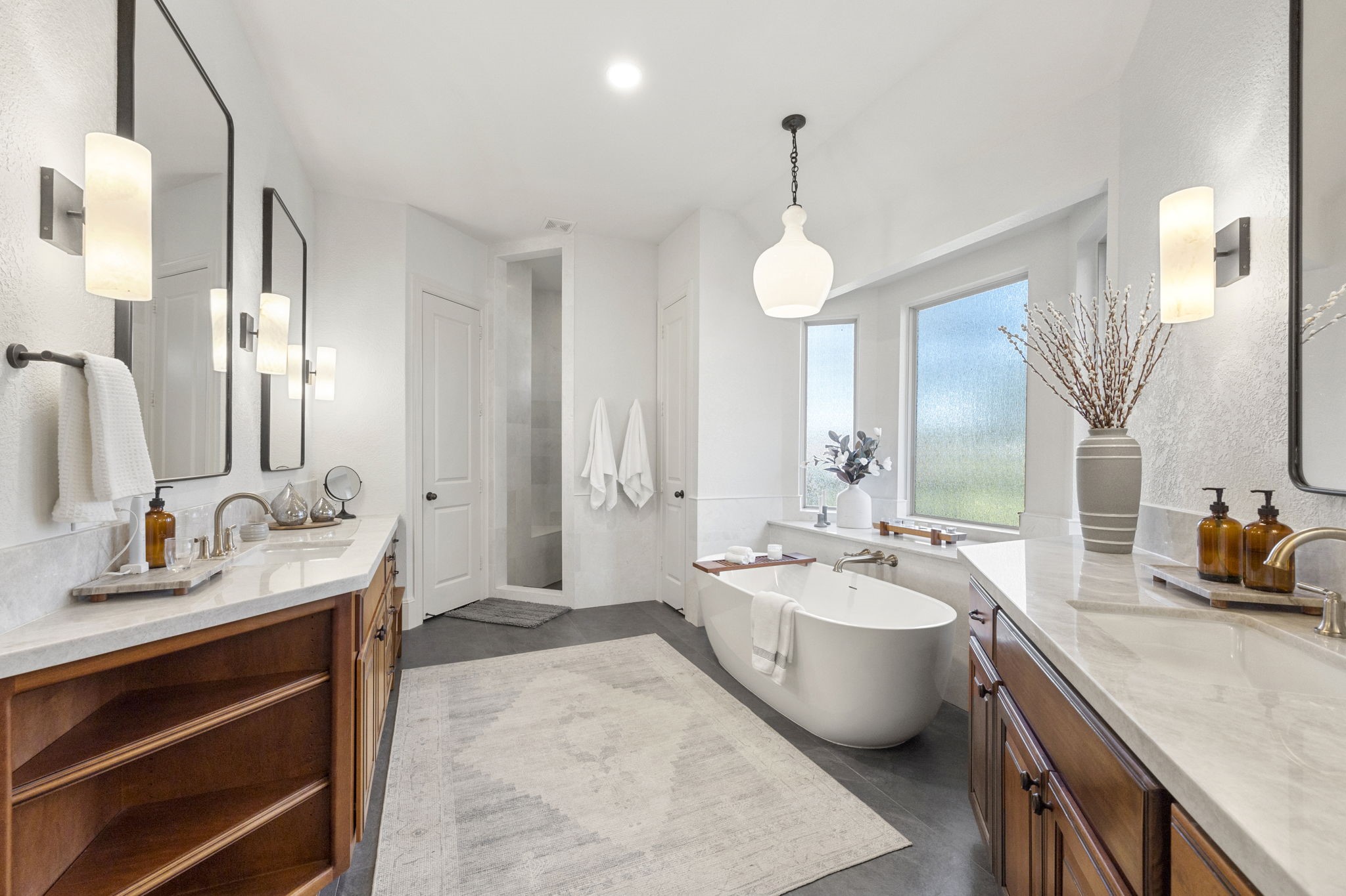 Totally renovated primary bathroom features high end finishes throughout! Oversized tile, beautiful custom vanities, a separate soaking tub, and large walk in shower is all ready to take the stress of the day away!