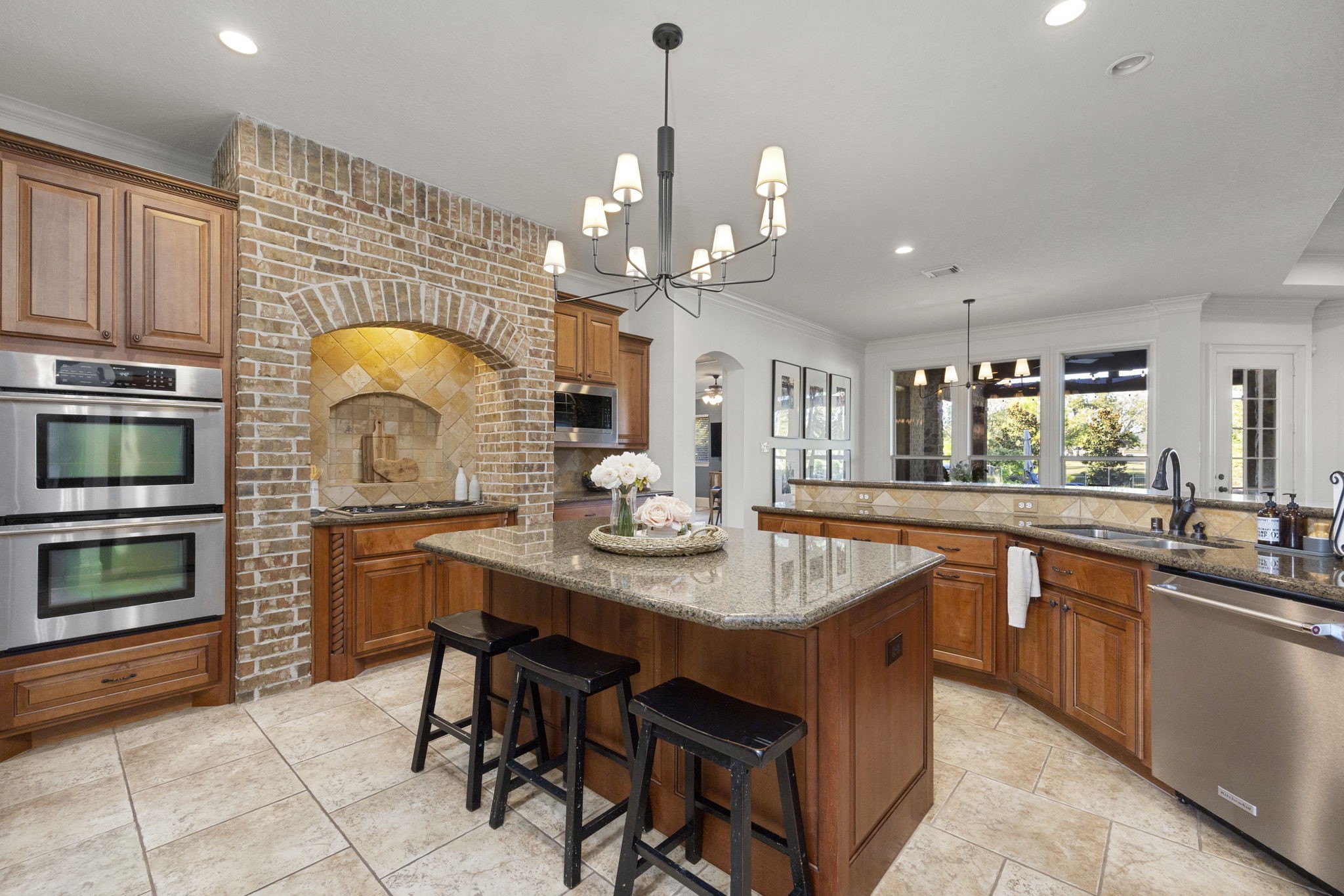 Great view of the handsome brick alcove cooking area, Double Ovens, and open layout looking into the breakfast and living rooms.