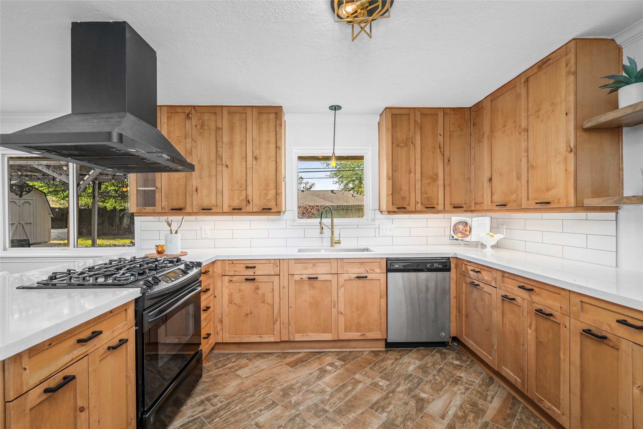 The kitchen updates include new countertops and backsplash, just the right amount of floating shelves, and a new sink and fixtures