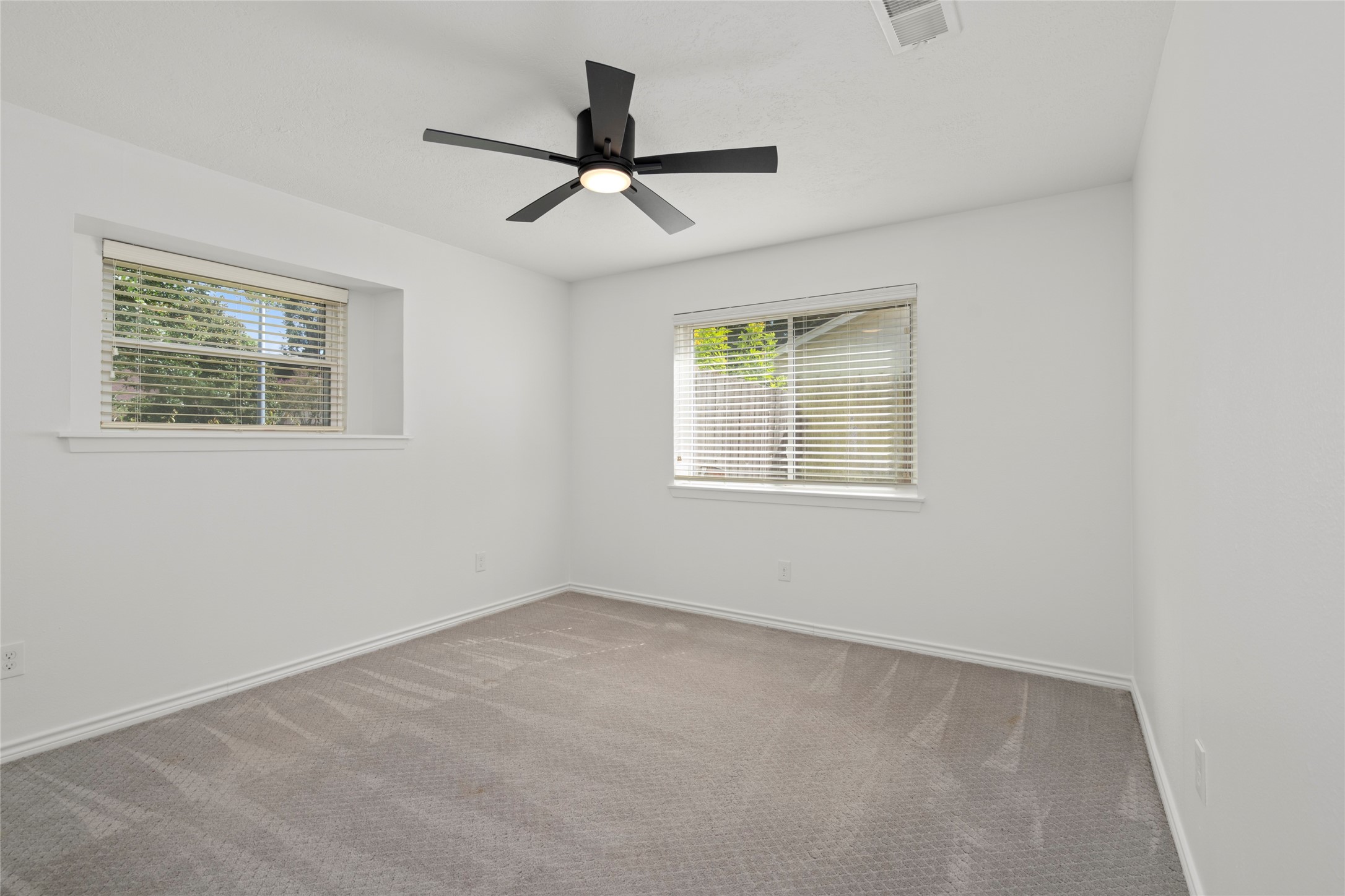 First of two secondary bedrooms with plush carpeting