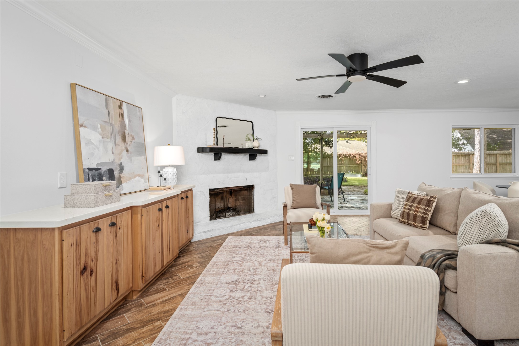 The heart of the living room is the corner, wood-burning fireplace and delightful built ins. Natural light flows from the new sliding doors opening to the spacious backyard.