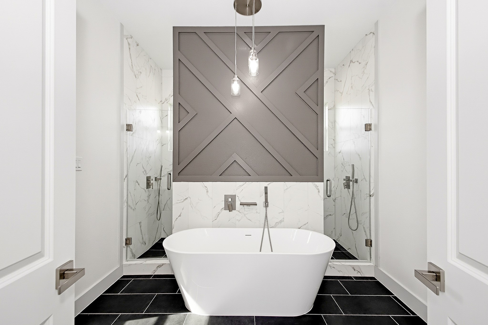 Luxurious 16x12 primary bathroom featuring a sleek freestanding tub, elegant walls, and dual glass showers, complemented by a striking geometric accent design.