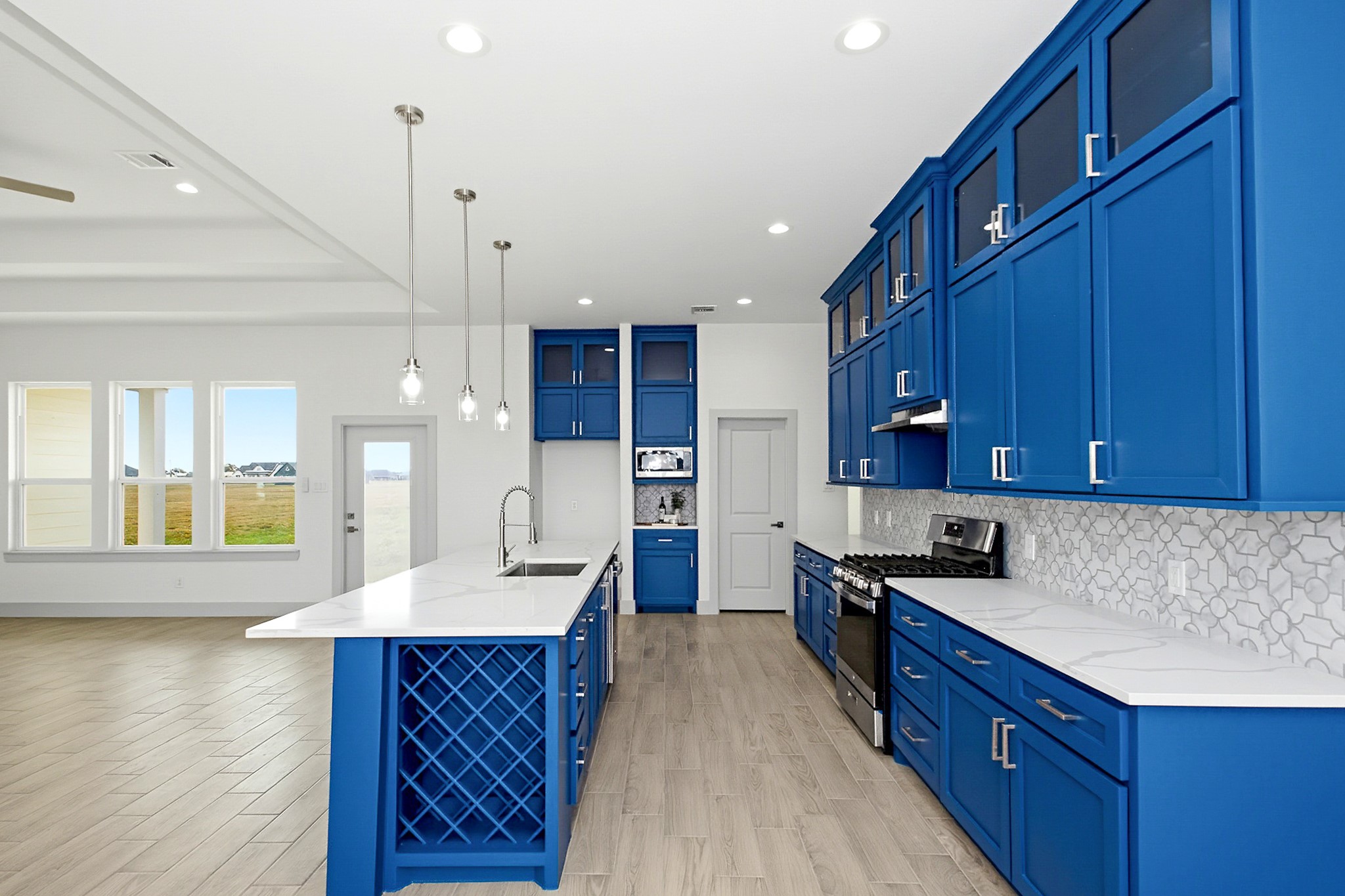 Stunning 19x14 kitchen with vibrant blue cabinetry, sleek quartz countertops, and modern stainless-steel appliances, all complemented by an open layout and ample natural light.