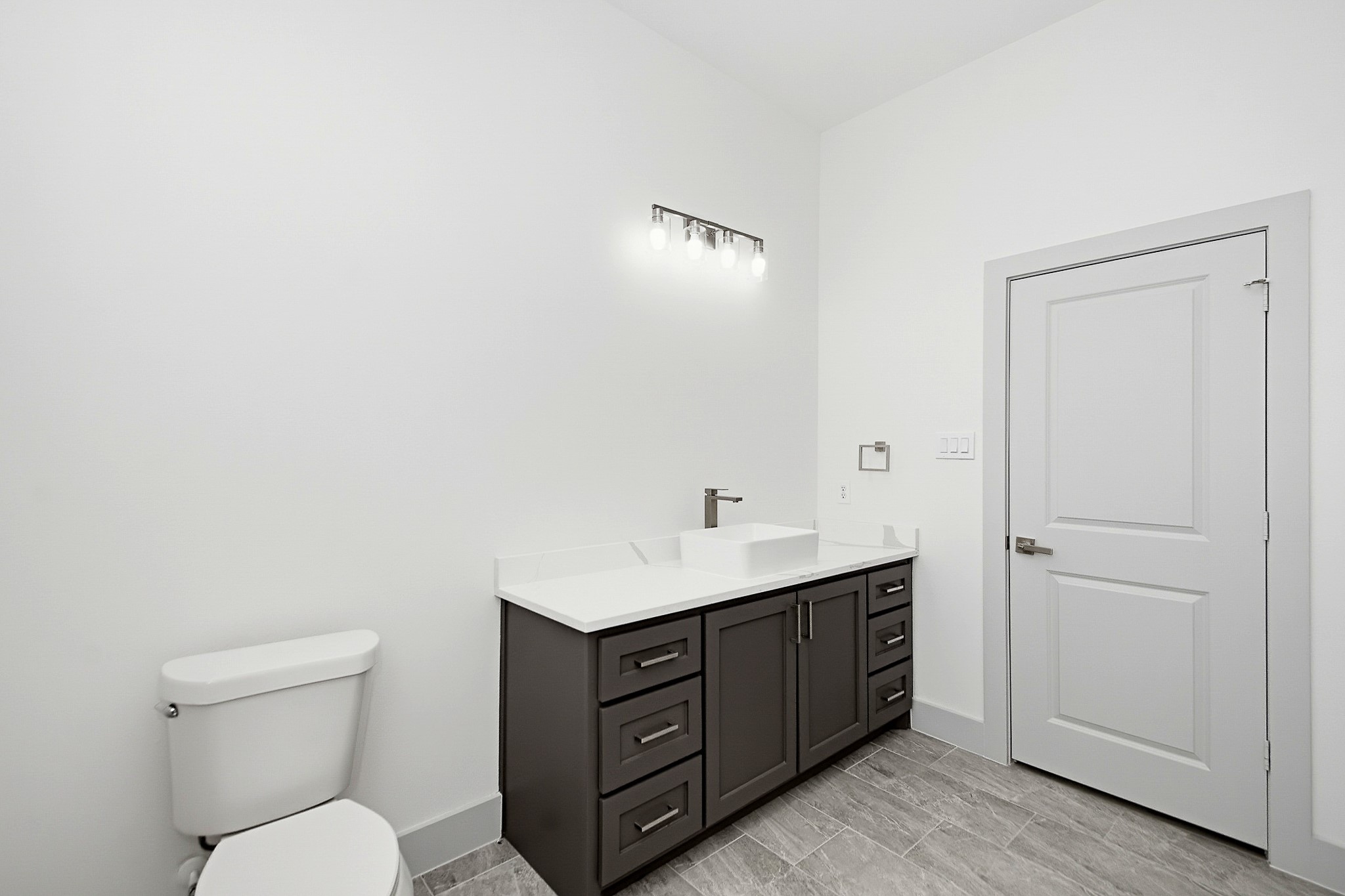 Bright and modern 10x10 secondary bathroom featuring a sleek vanity with ample storage, contemporary lighting, and elegant tile flooring.