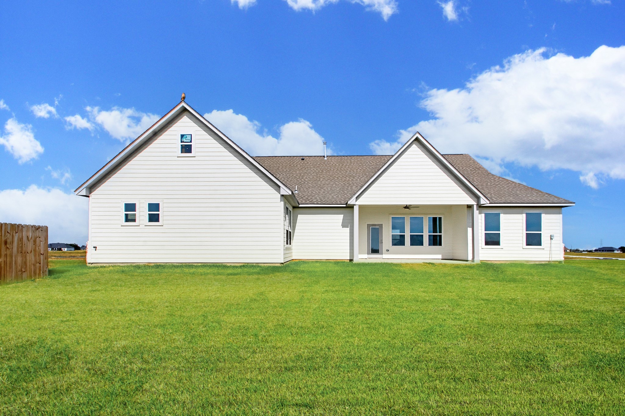 Charming modern home with clean white siding, a spacious backyard, and a covered patio perfect for outdoor relaxation. Property sits on a 1 acre lot.