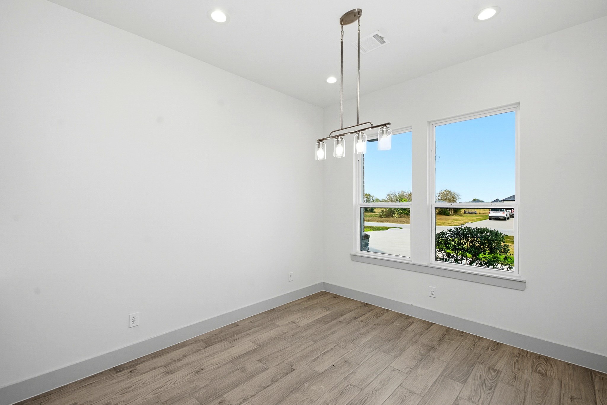 Bright 10.5x10.5 dining area with modern lighting, large windows, and elegant flooring, offering a cozy, inviting atmosphere.