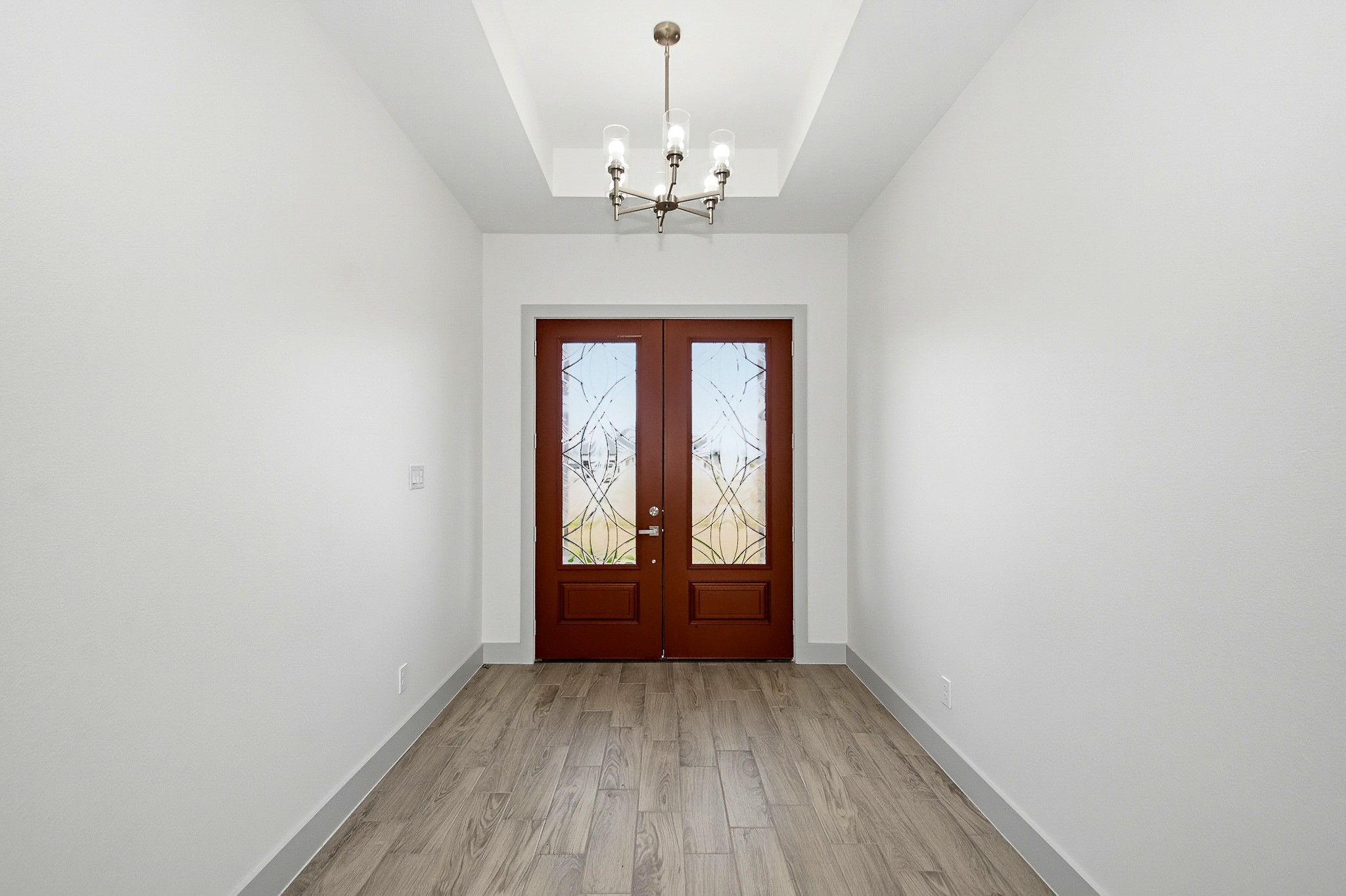 Extra spacious entry way with custom glass etched double doors.