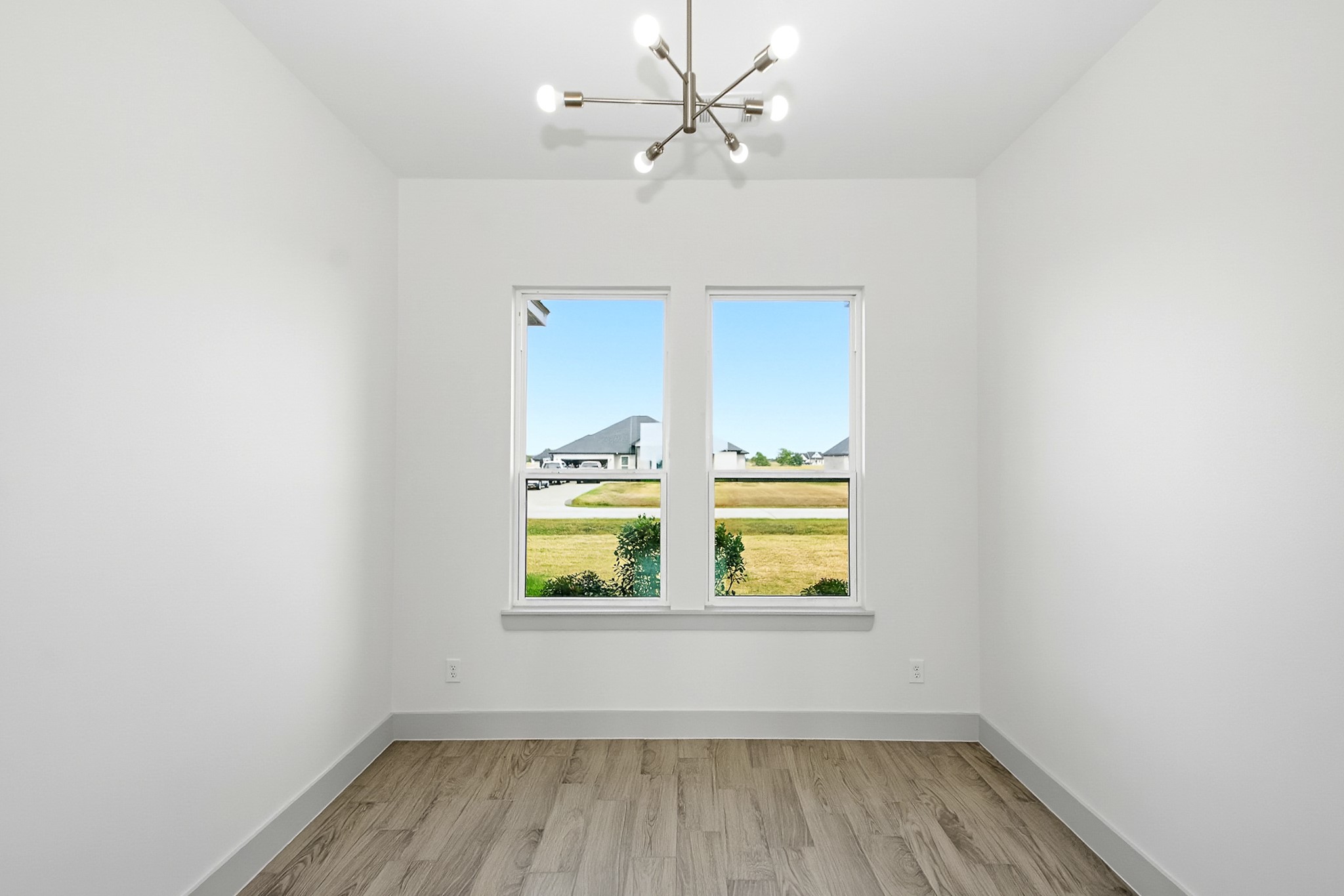 Bright and airy 10.5x10 office space with large windows offering beautiful natural light, complemented by sleek tile flooring and a modern light fixture.