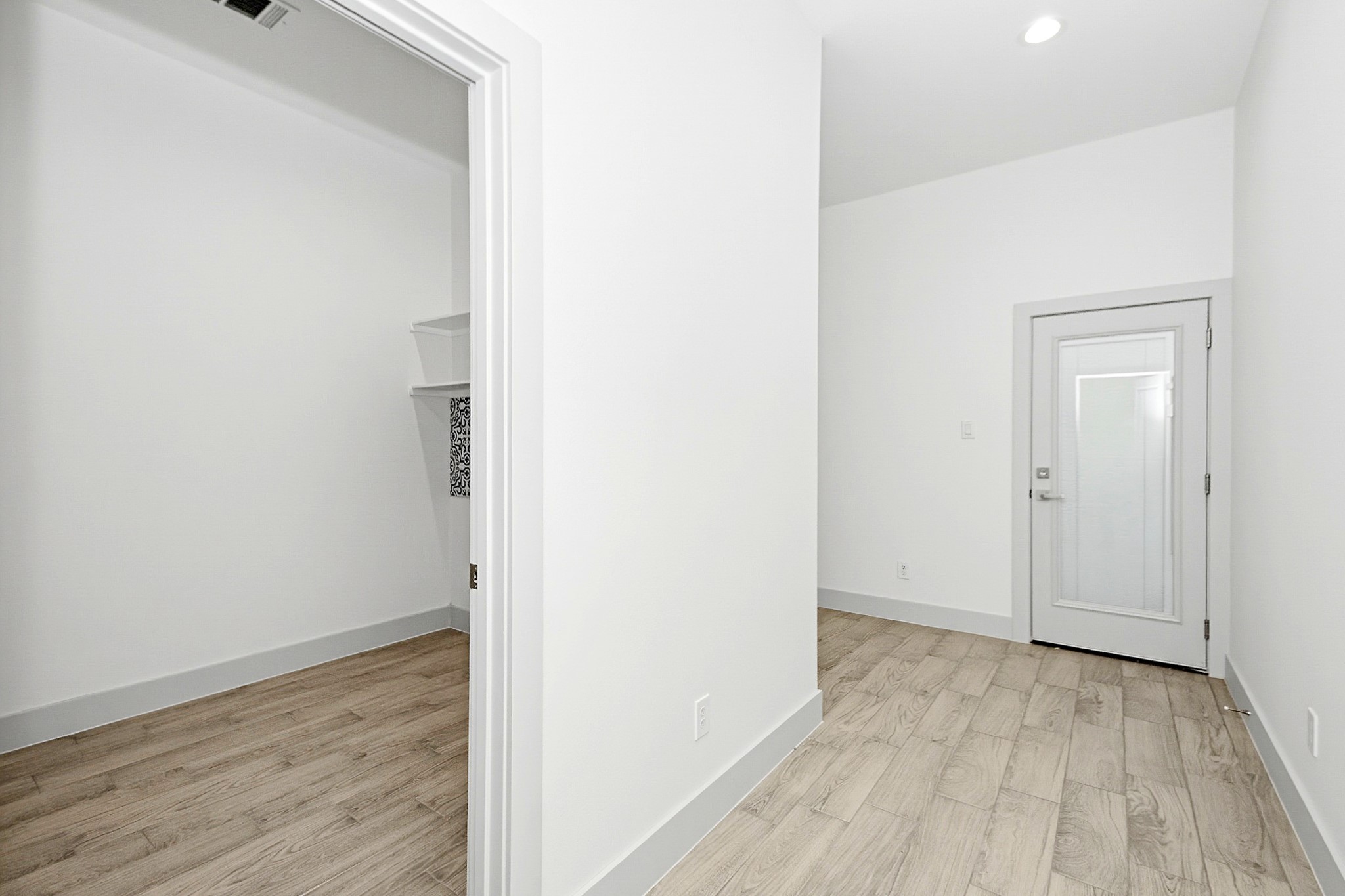Bright and inviting space featuring sleek tile flooring, a spacious 8x8 laundry room and a modern door with frosted glass detail leading to the spacious double wide car garage.