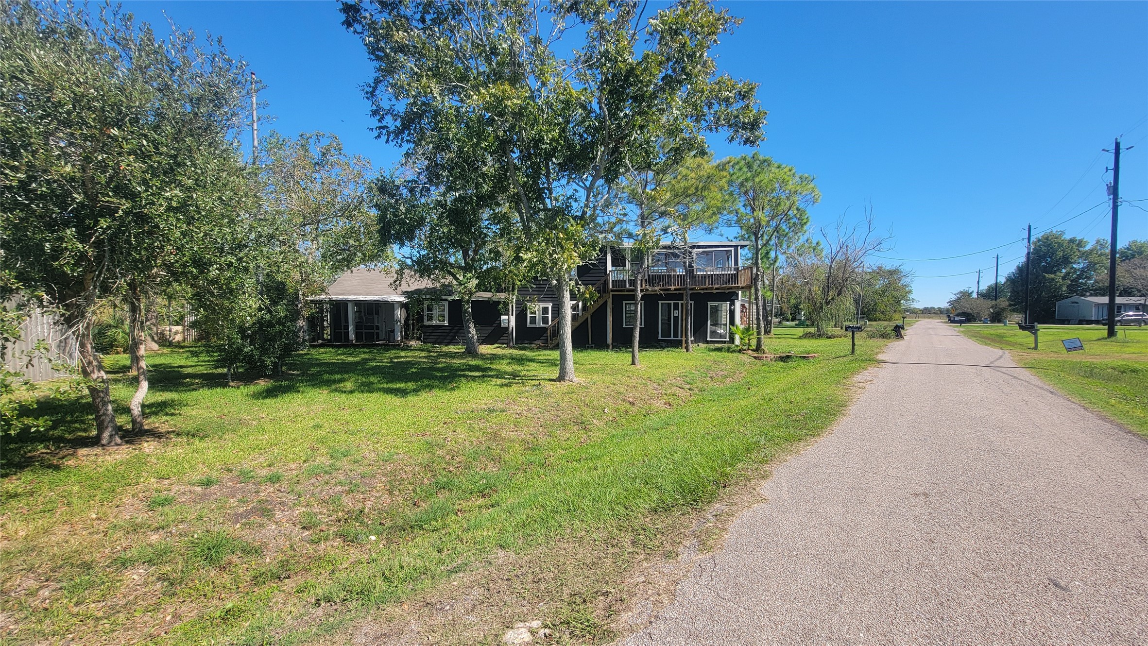 Charming two-story home surrounded by lush greenery, set on a quiet street. Features a spacious yard with mature trees, perfect for enjoying nature and outdoor activities.