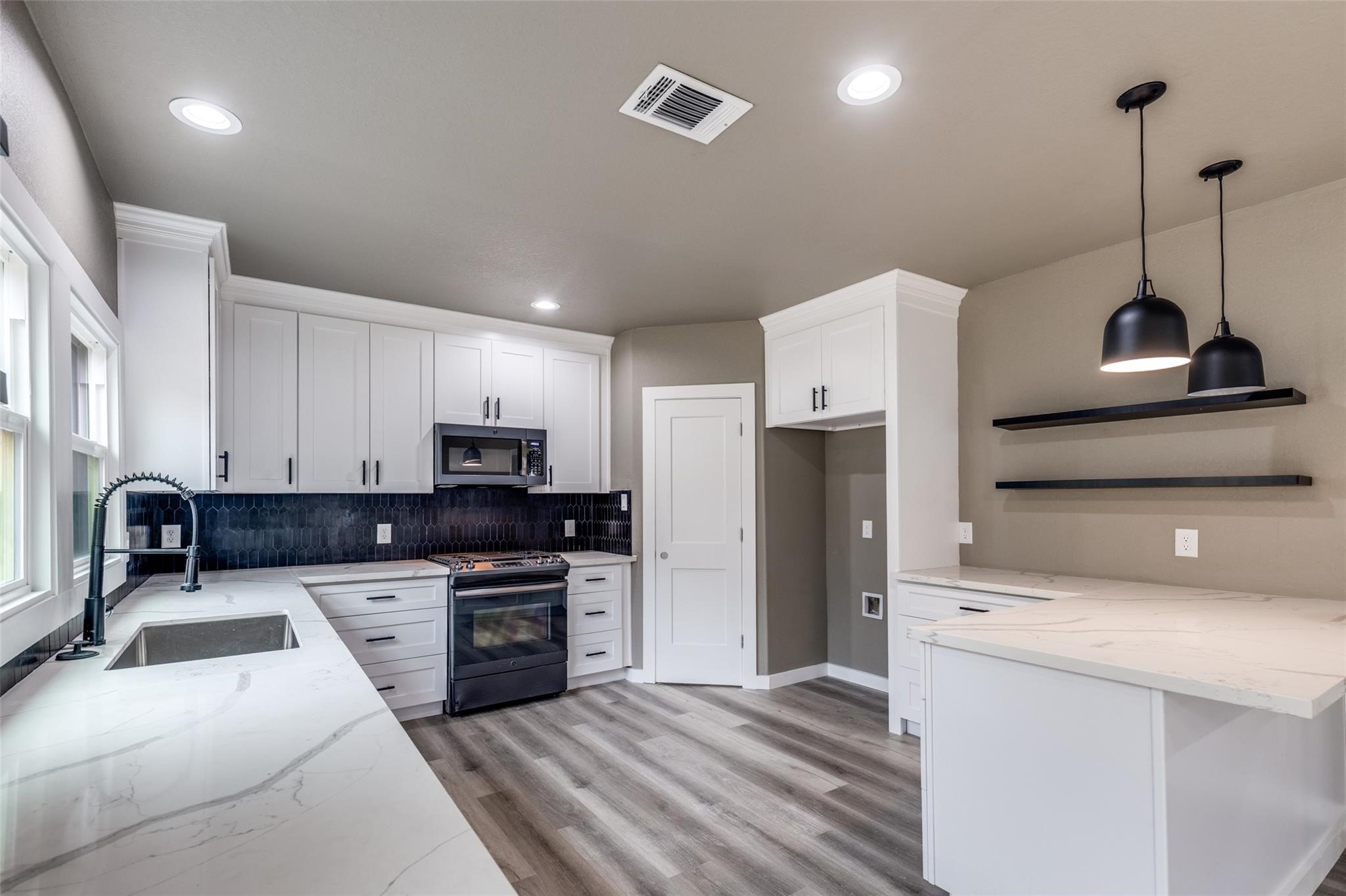 Wide angle view of the open concept kitchen and living area, light filled, move in ready, and made for entertaining. Wide angle view of the open concept kitchen and living area, light filled, move in ready, and made for entertaining.