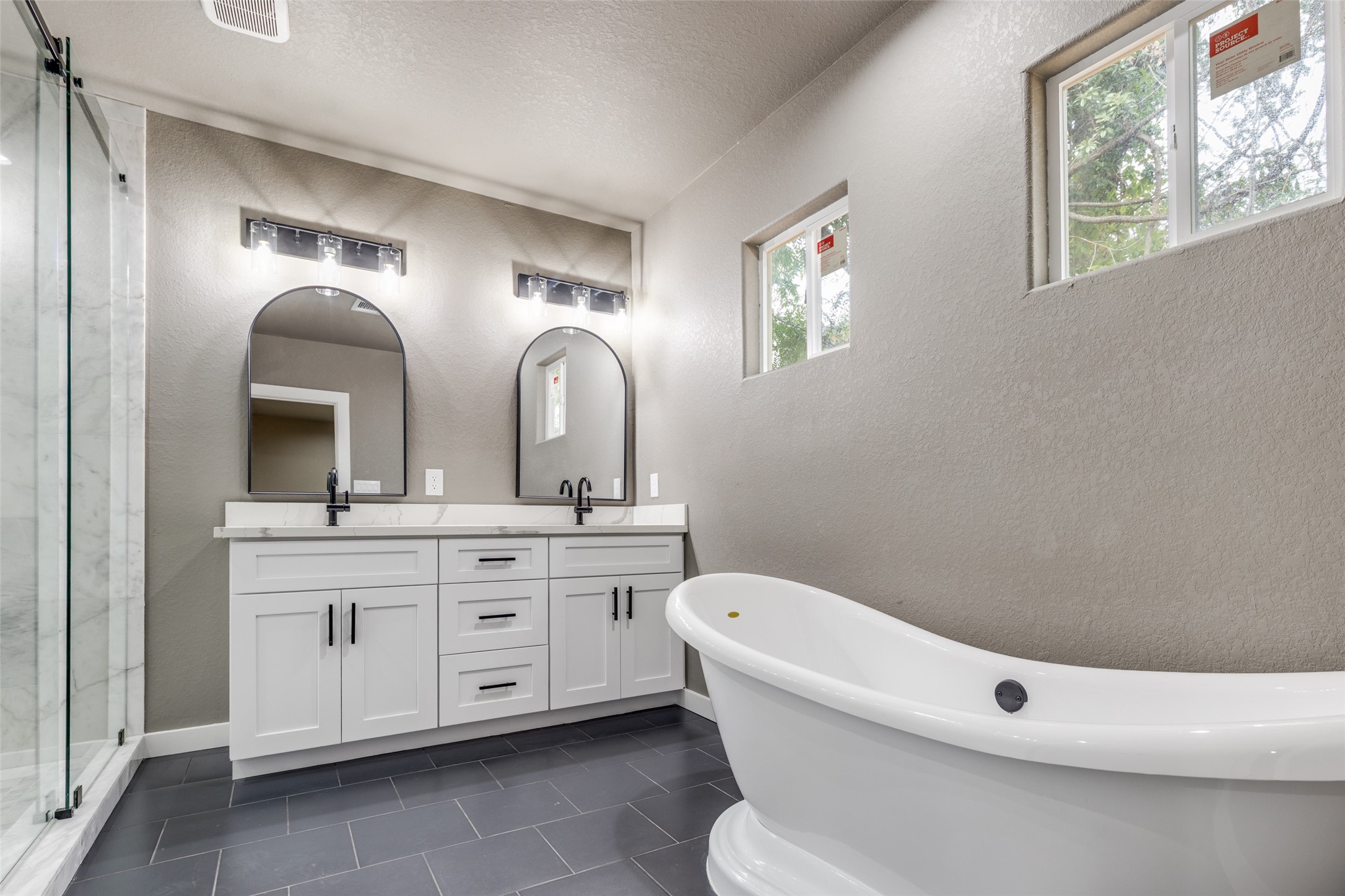 Spa style primary bath with a freestanding soaking tub, double vanity, and bright natural light, your everyday reset.