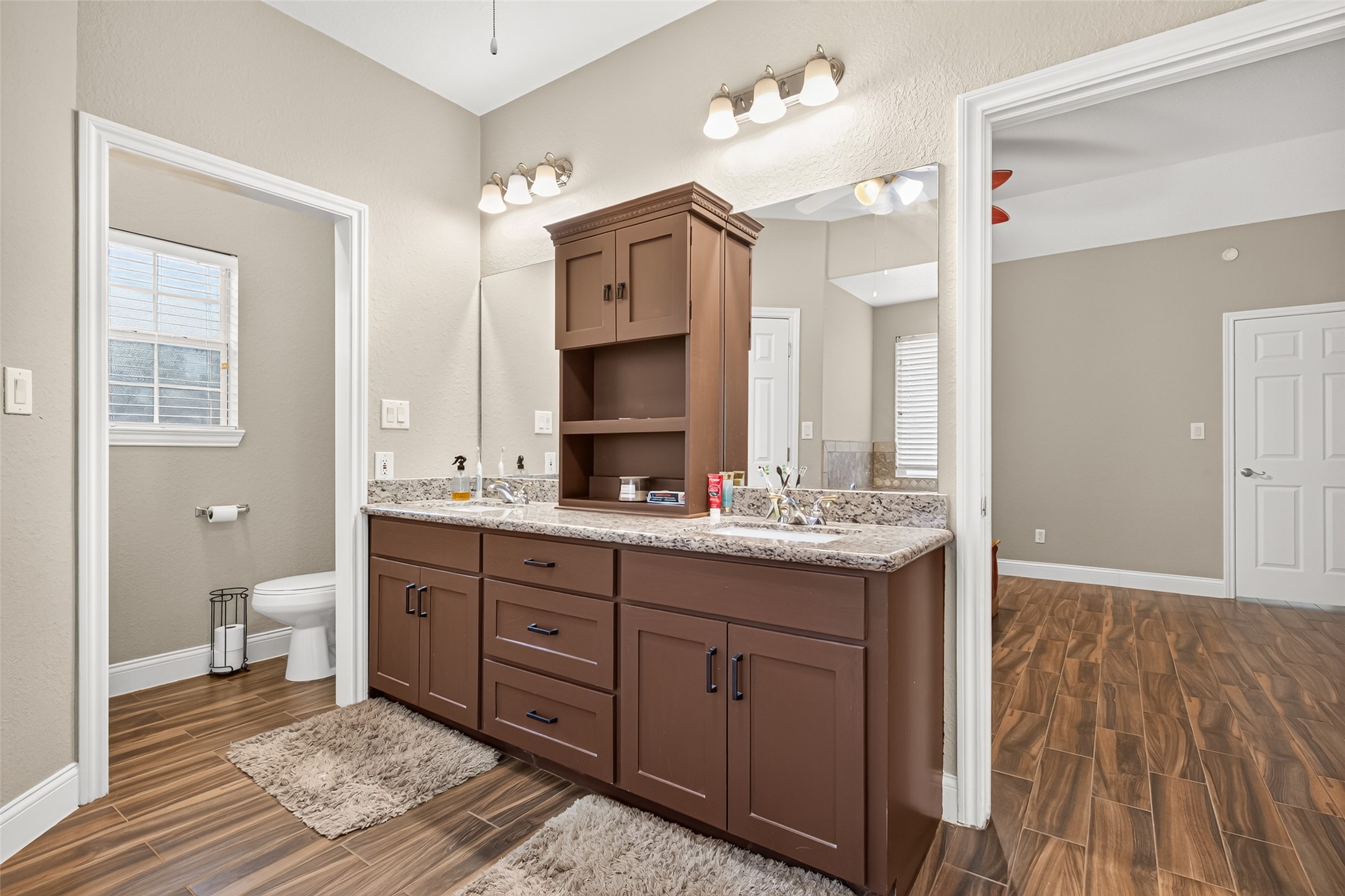 Another look at the thoughtfully updated primary bathroom, showcasing the custom cabinetry, dual sinks, and separate walk-in shower.