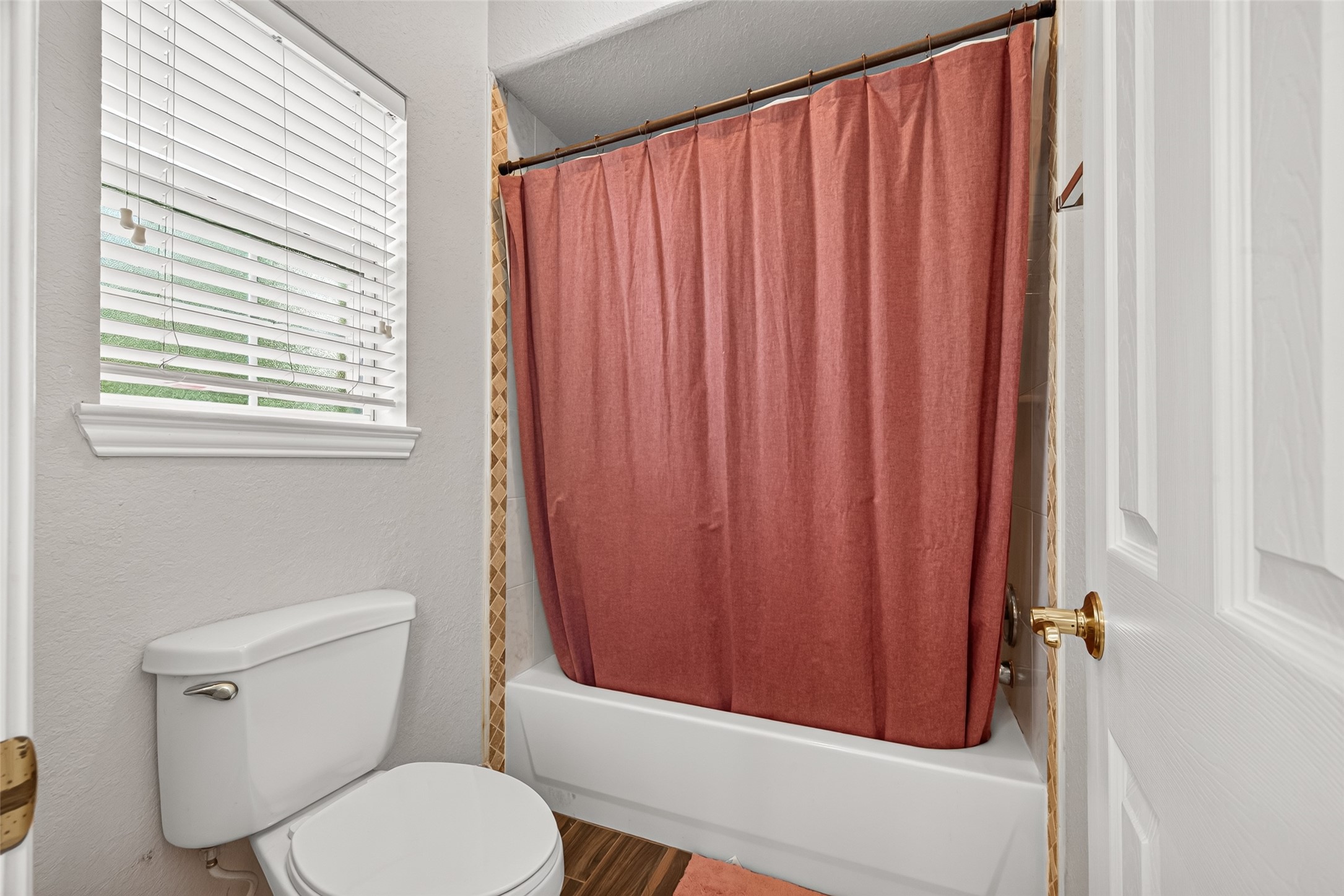 Additional view of the secondary bathroom showcasing the tub and shower combination, natural light, and convenient layout.