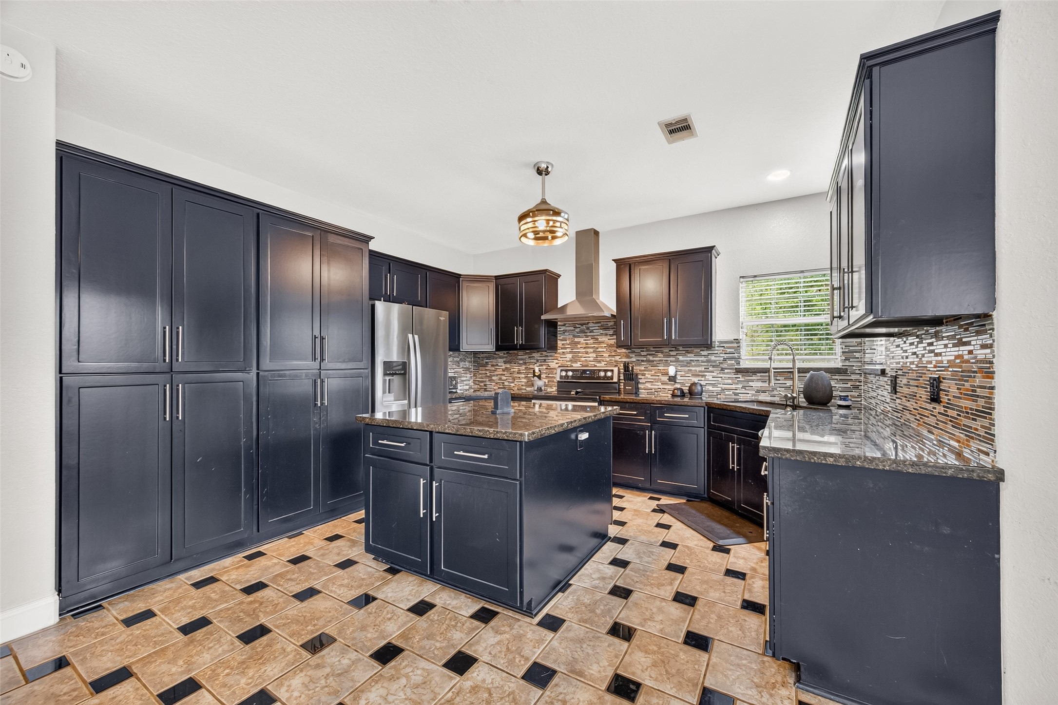 Beautifully designed kitchen offering abundant cabinet storage, generous counter space, and a stylish tile backsplash.