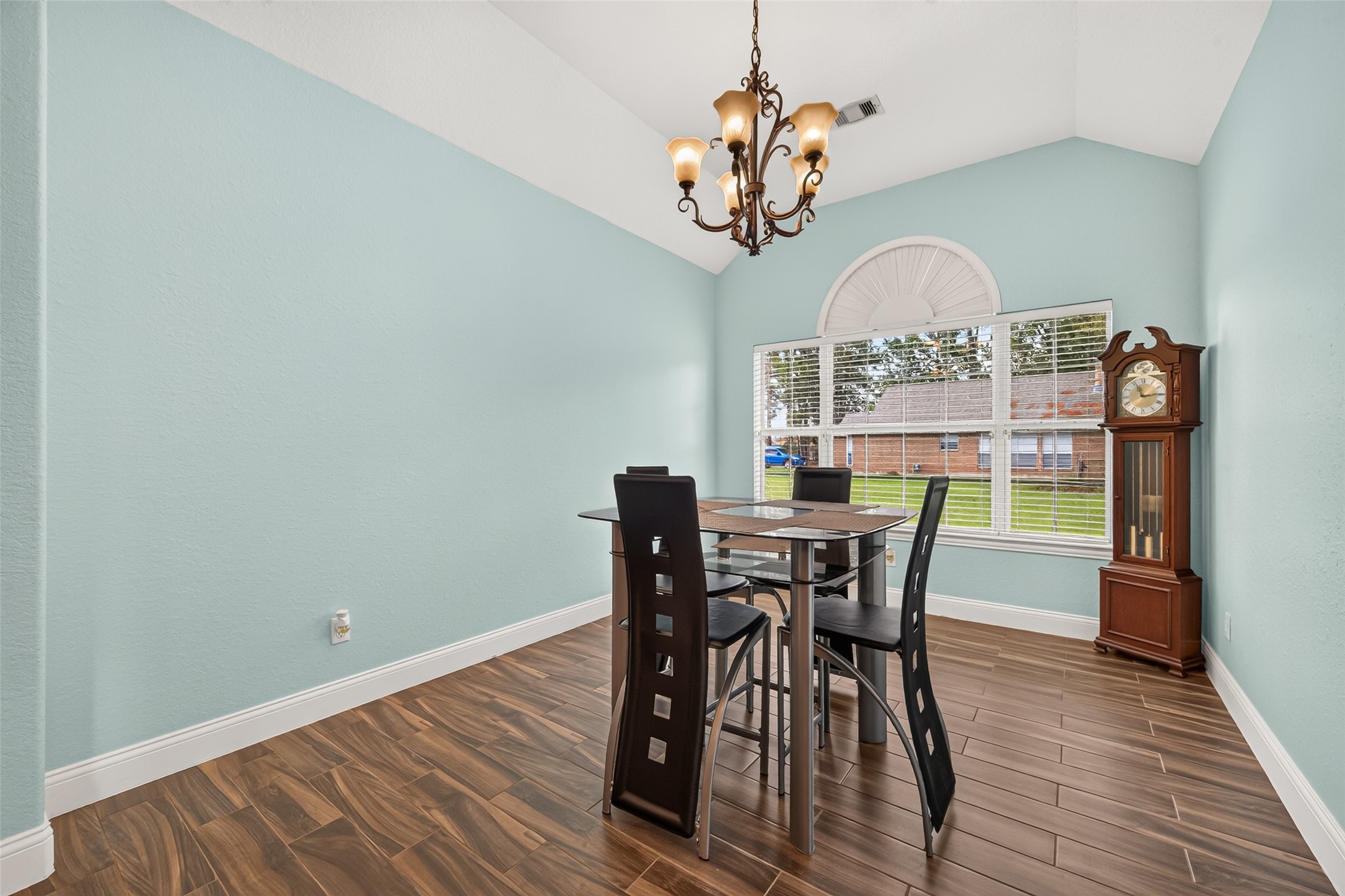 Beautiful formal dining room featuring soaring ceilings, elegant lighting, and gorgeous wood-look flooring. A wonderful space for entertaining!