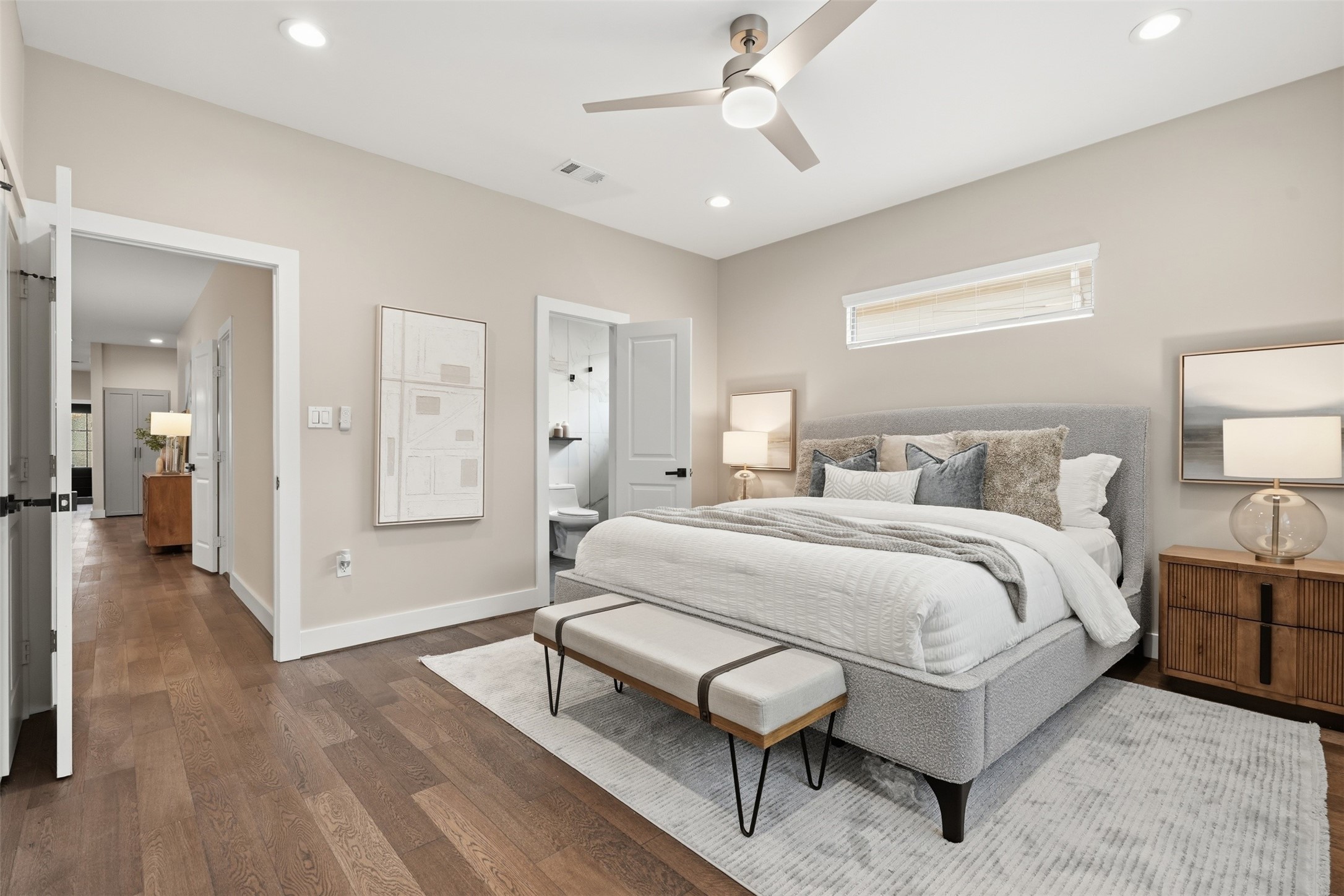 Relaxing primary suite with hardwood floors and a private en-suite bathroom
