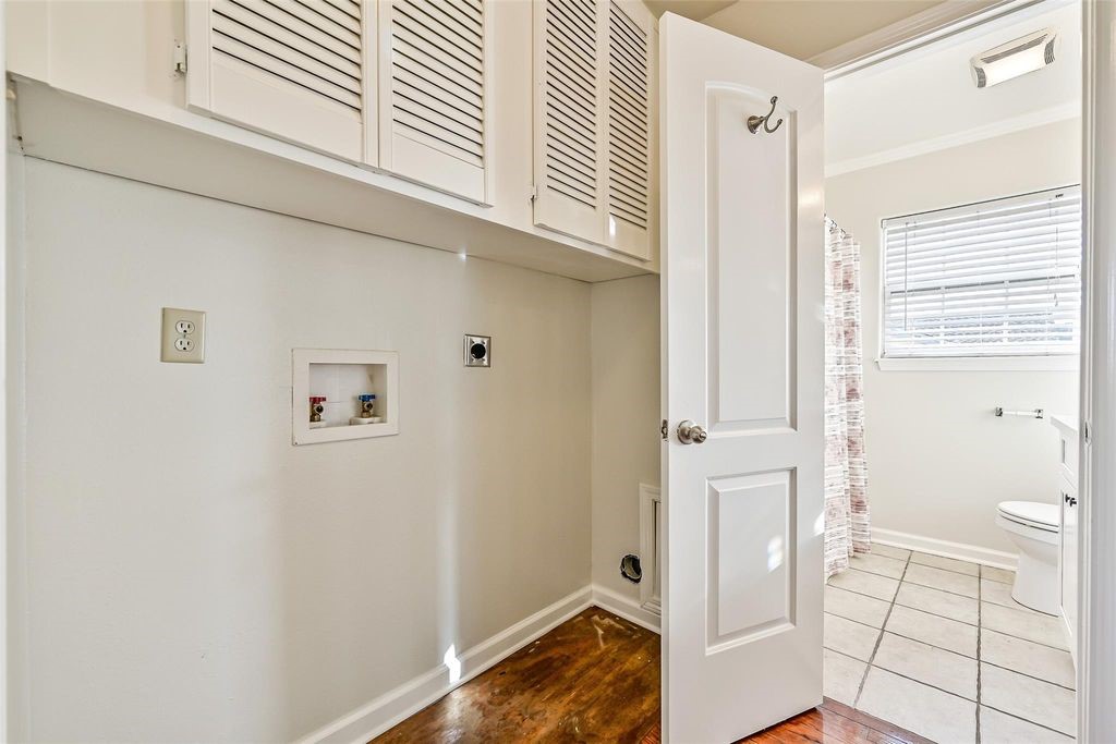 Washer and dryer connections with storage above and hall storage closet directly behind.