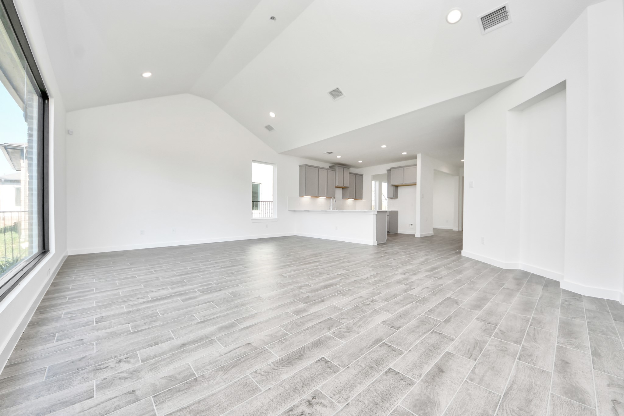 Gather the family and guests together in your lovely living room! Featuring soaring high ceilings, recessed lighting, ceiling fan, custom paint, gorgeous floors, and large windows that provide plenty of natural lighting throughout the day.