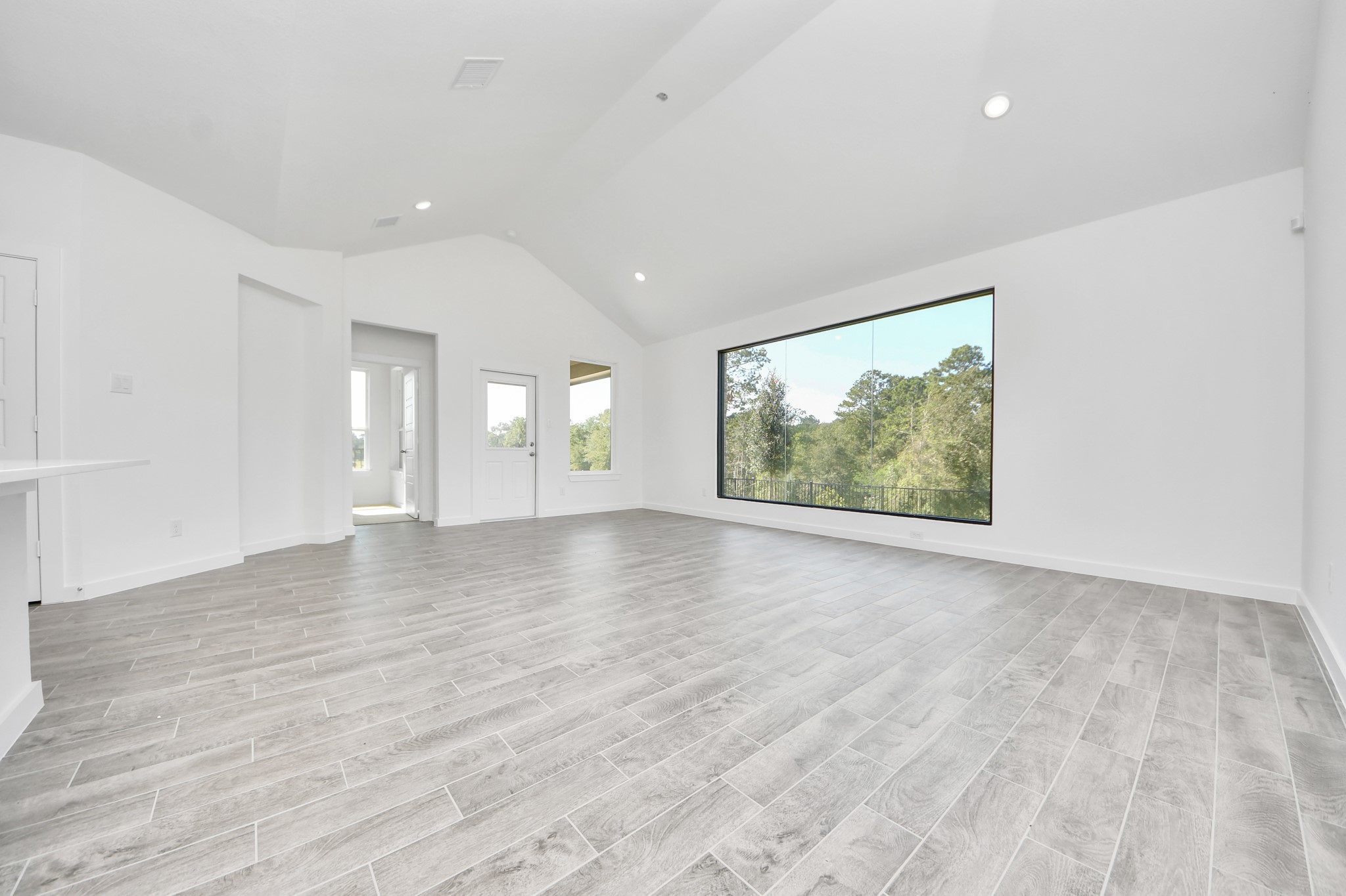 Gather the family and guests together in your lovely living room! Featuring soaring high ceilings, recessed lighting, ceiling fan, custom paint, gorgeous floors, and large windows that provide plenty of natural lighting throughout the day.