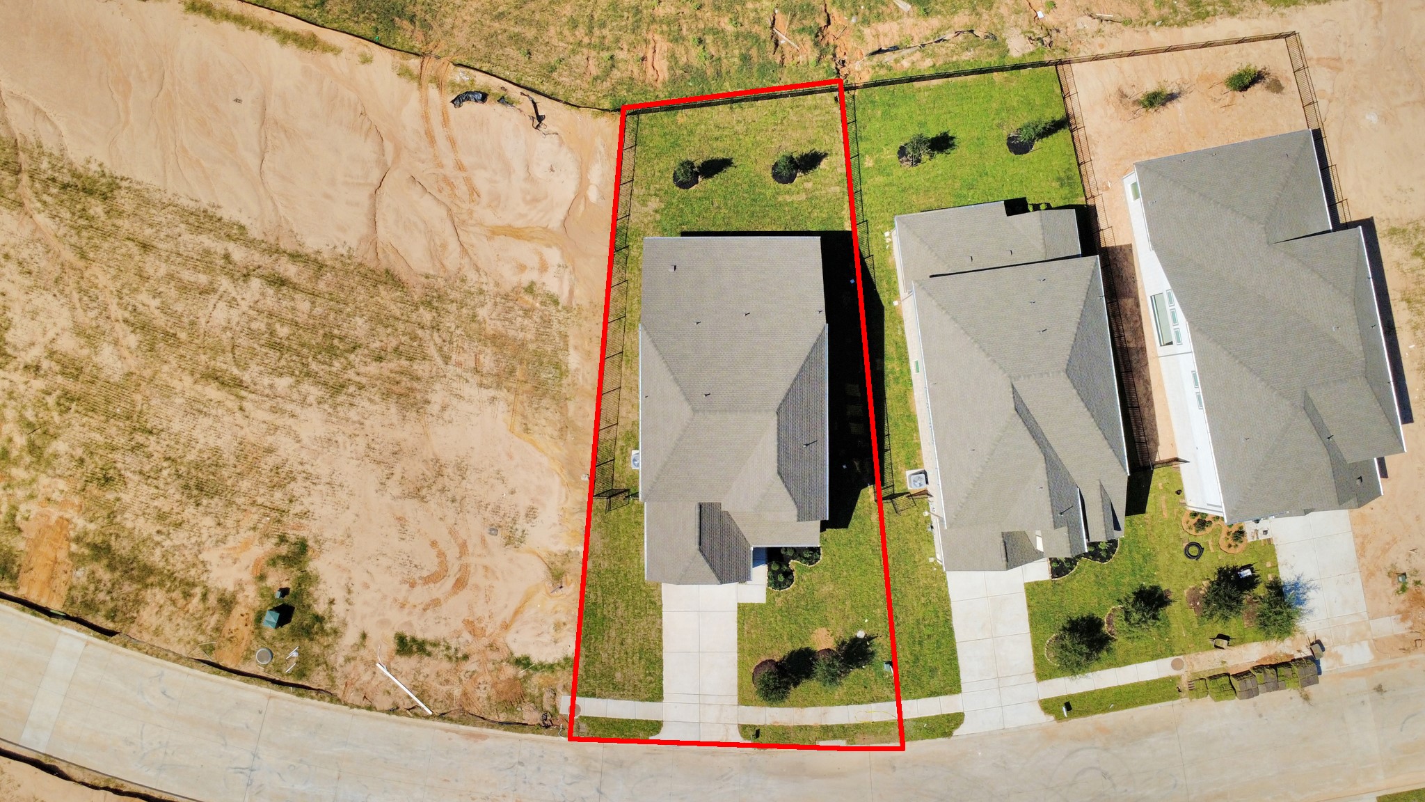 An aerial view of a spacious subdivision lot, highlighting a well-maintained yard and a fully fenced perimeter, offering both privacy and expansive outdoor space.